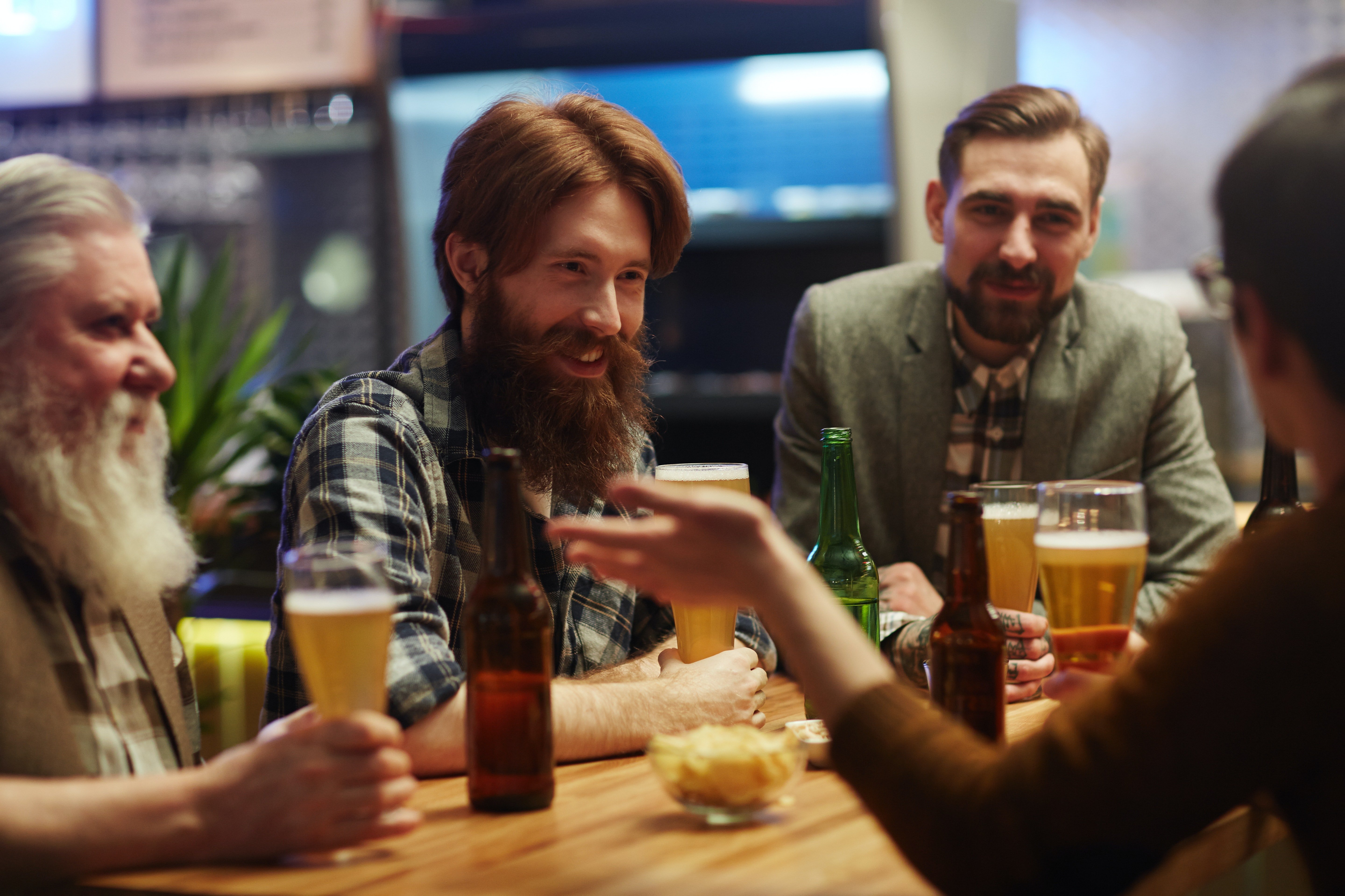 People smiling and talking at a bar | Photo: Pexels
