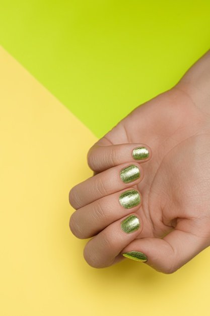 Manos con uñas verdes. │Foto: Freepik