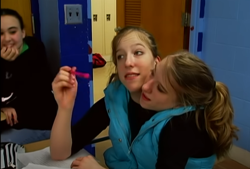 Abby and Brittany Hensel are at school, from a video post dated December 2, 2022 | Source: YouTube/Origin