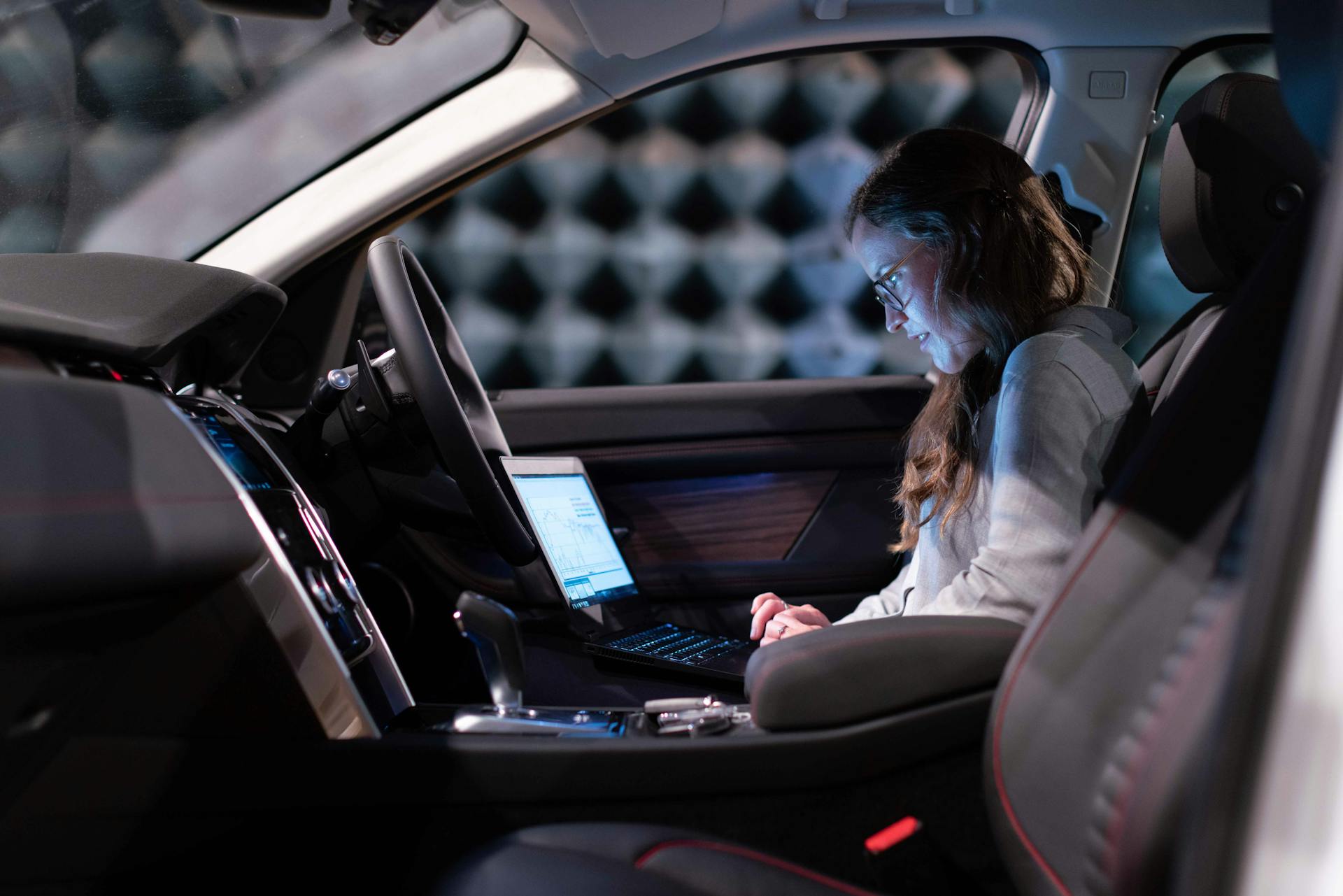 A woman using her laptop in a car | Source: Pexels