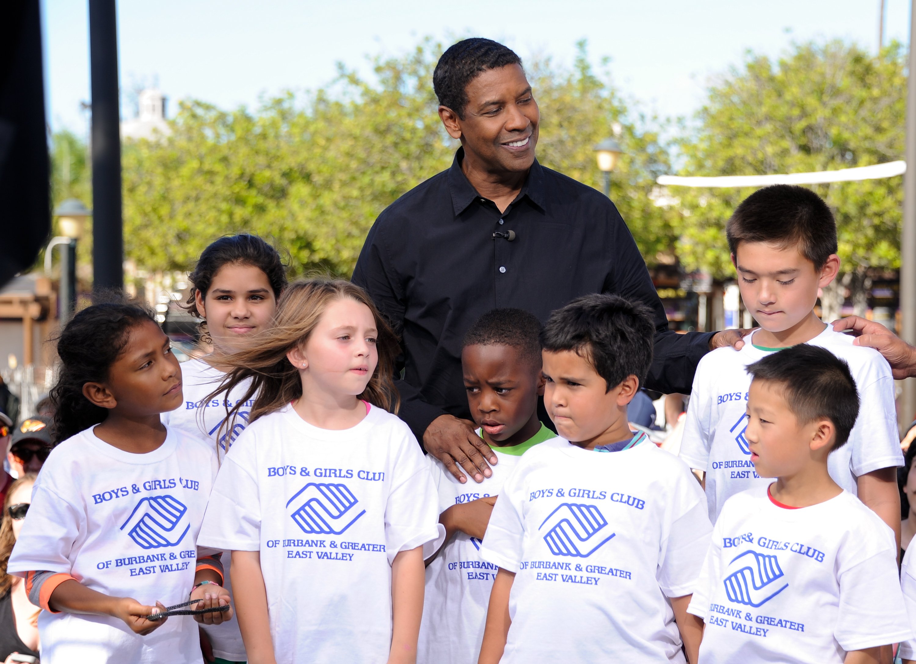  Denzel Washington poses with children from the Boys and Girls Club "Extra" at Universal Studios Hollywood on September 25, 2014 in Universal City, California. | Source: Getty Images