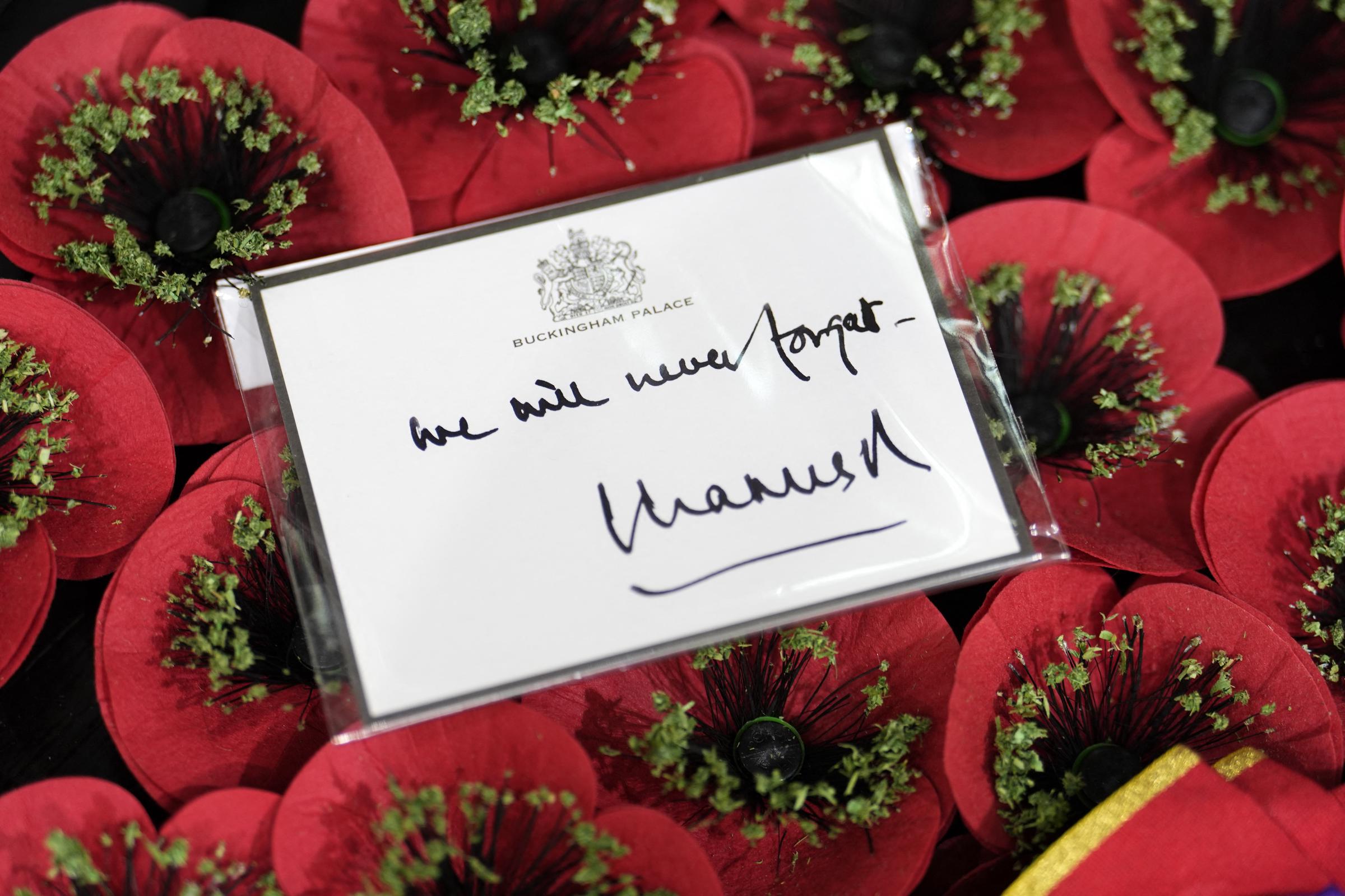 A handwritten note is pictured on the wreath laid by King Charles III at Westminster Abbey in London on May 8, 2025 | Source: Getty Images