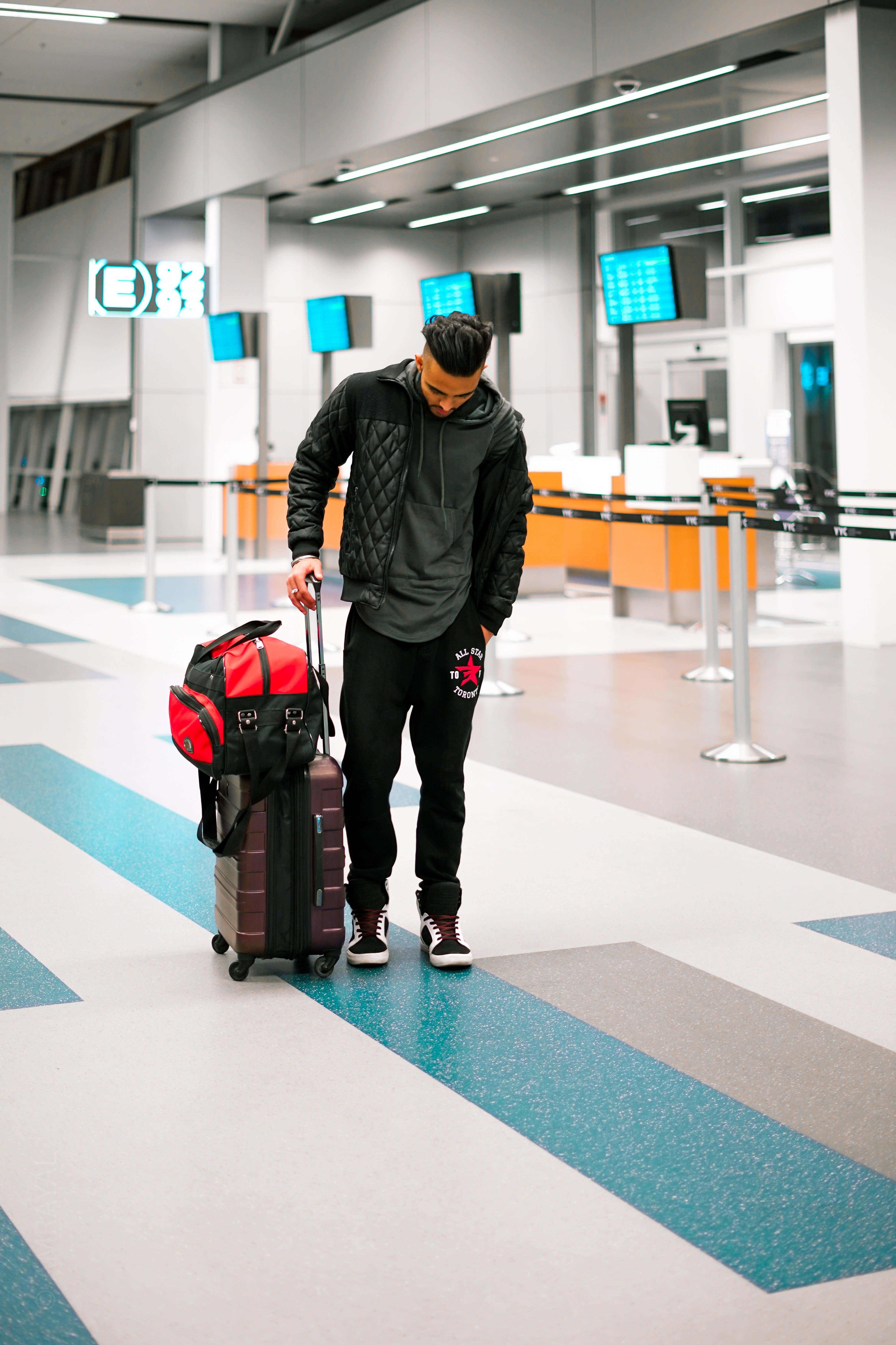 Pictured - A man at the airport carrying his luggage while looking down. | Source: Pexels 