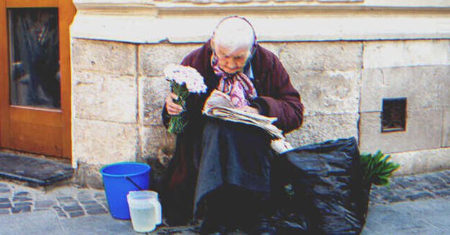 Anciana sentada en la calle con un ramo flores en su mano. | Foto: Shutterstock