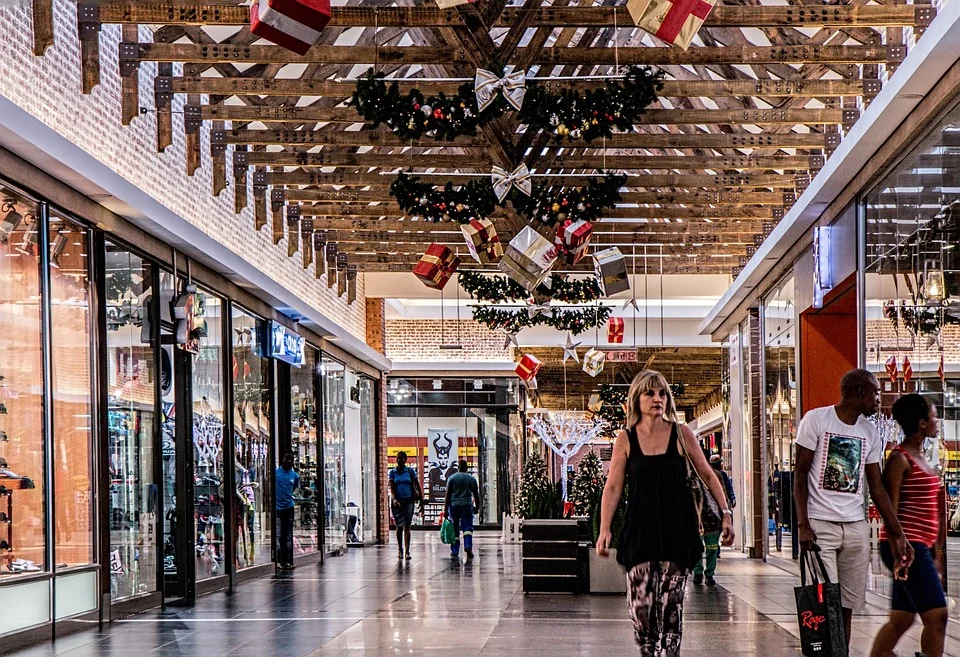 Personas caminando por el pasillo de un centro comercial decorado con adornos navideños. | Foto: Pixabay