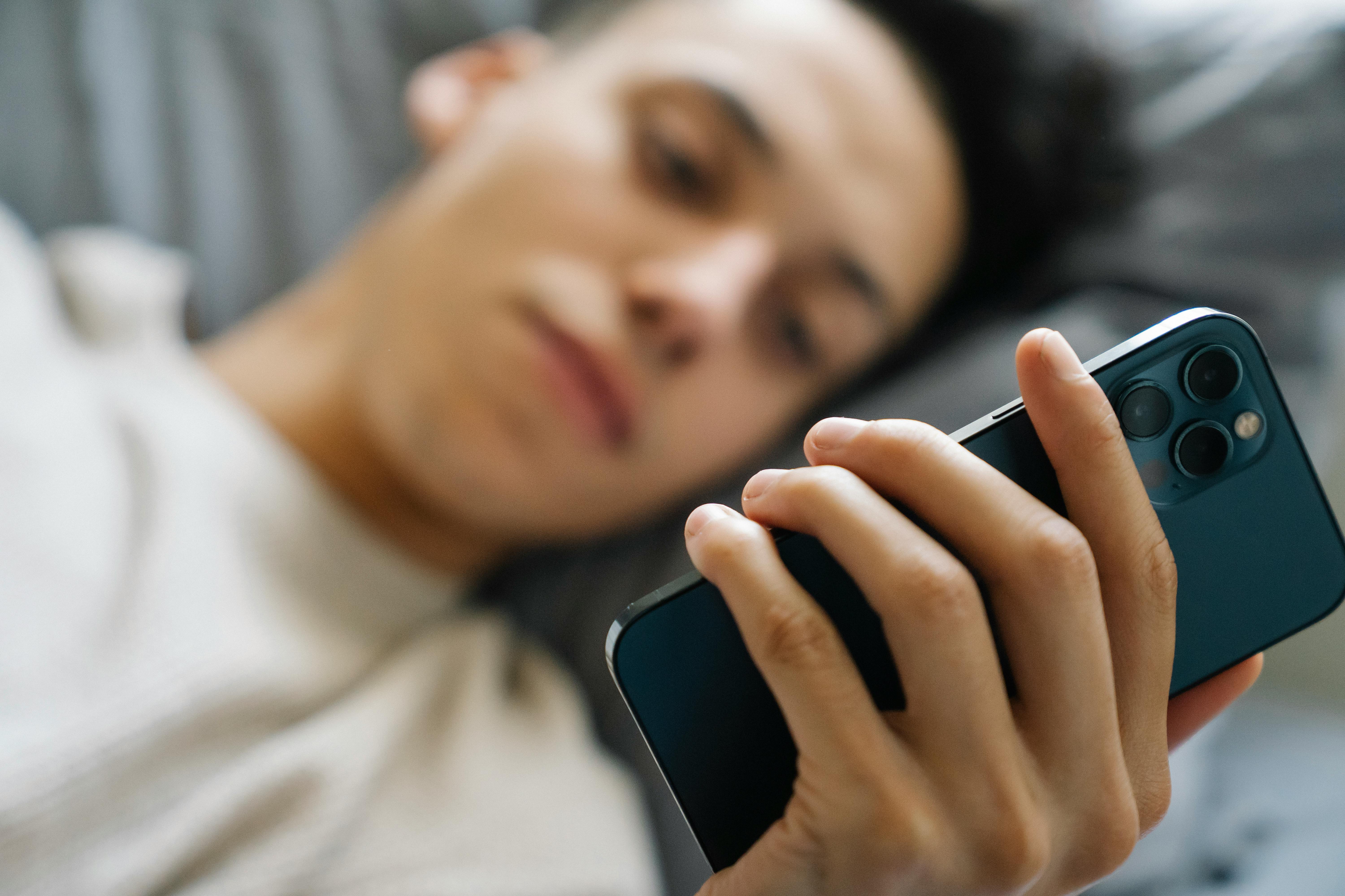 A faded picture of a young man using his phone | Source: Pexels
