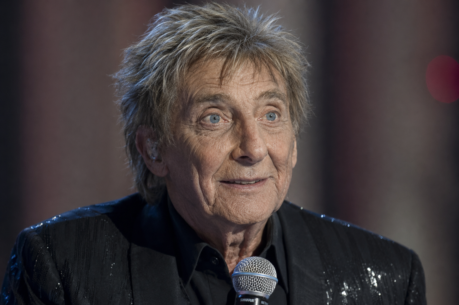 his version keeps Manilow's familiar stage styling while giving his face a more aged look. The contrast makes it easy to picture how different he might appear without changing the image around him. | Source: ChatGPT
