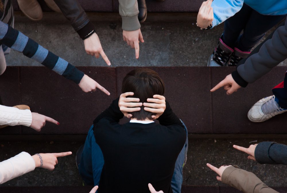 Grupo de estudiantes intimidando a un joven.|Fuente: Shutterstock Grupo de estudiantes intimidando a un joven.|Fuente: Shutterstock