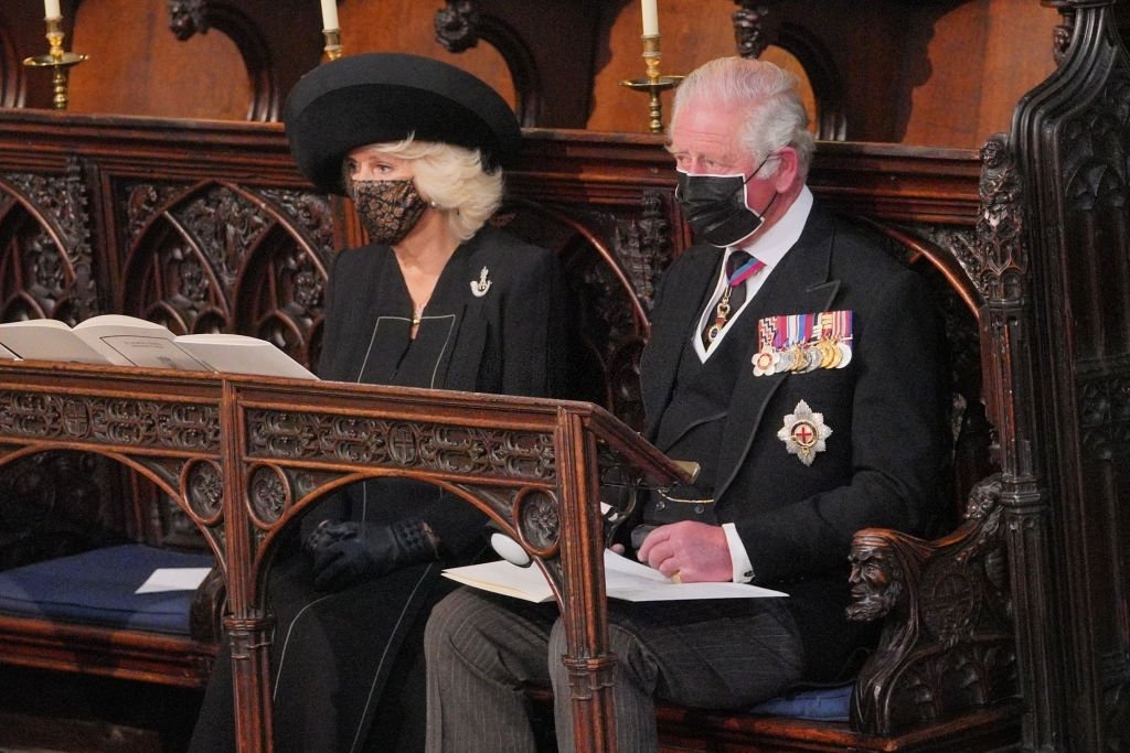 Camilla, duchesse de Cornouailles, et le prince Charles, prince de Galles, assis pendant le service funèbre du prince Philip, duc d'Édimbourg, dans la chapelle Saint-Georges du château de Windsor, à Windsor, à l'ouest de Londres, le 17 avril 2021. | Photo : Getty Images