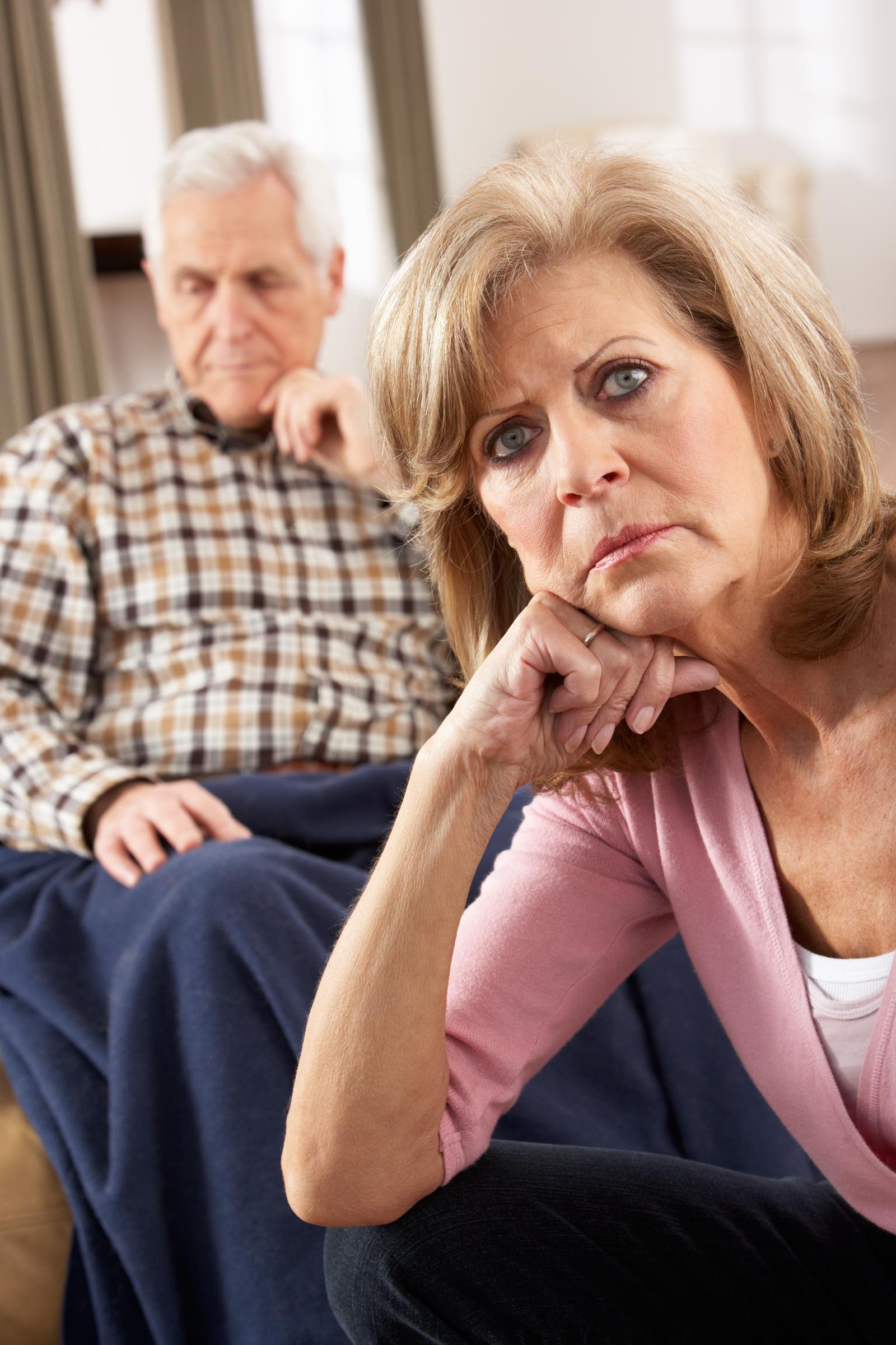 Woman frowning as her spouse sits behind her | Source: Shutterstock