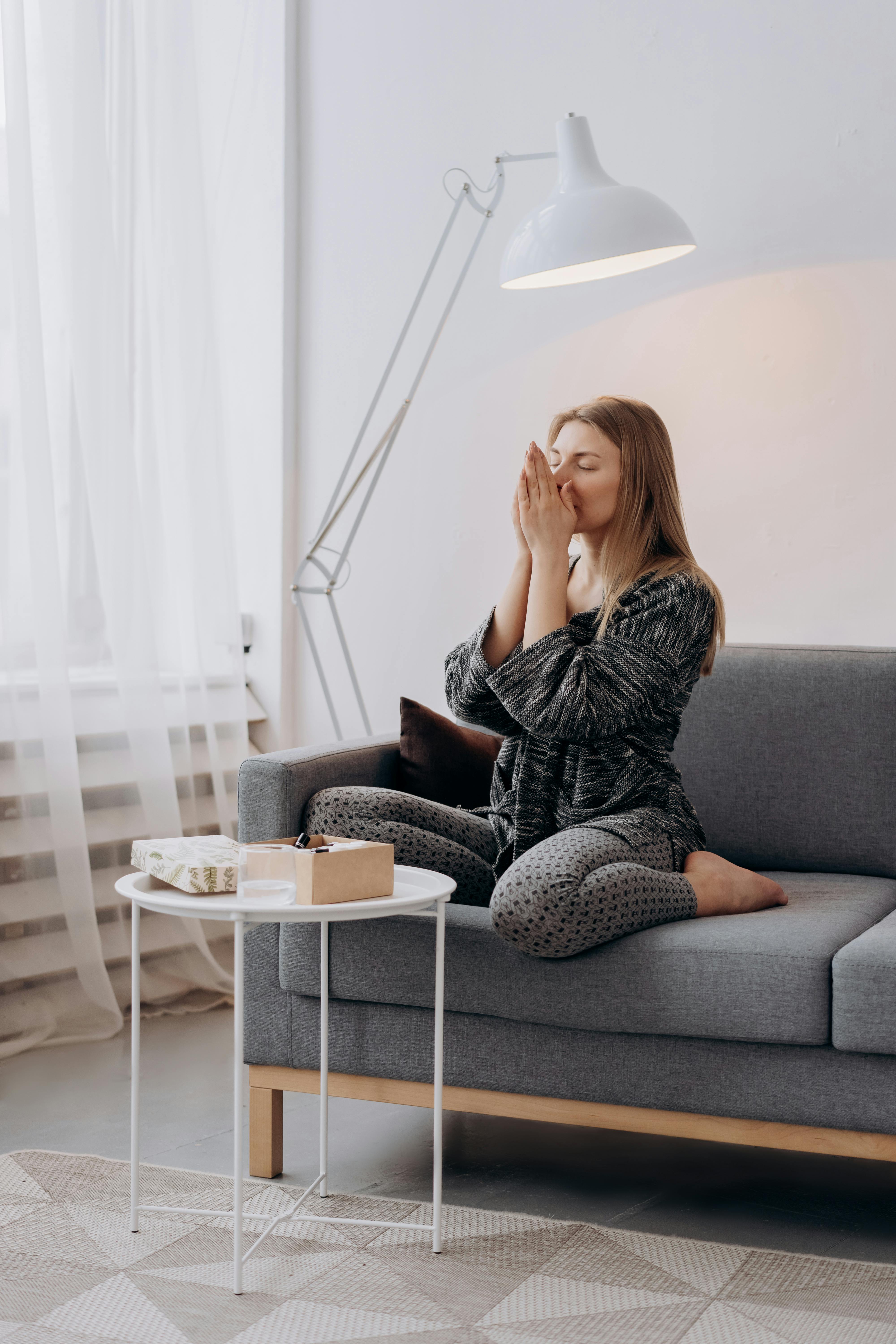 Woman in deep thought laying on the couch | Source: Pexels