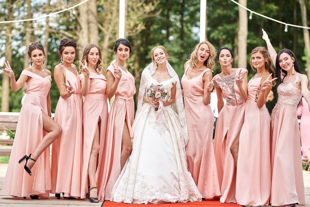A beautiful bride and her bridesmaids posing on the park on the wedding day. | Photo: Shutterstock.