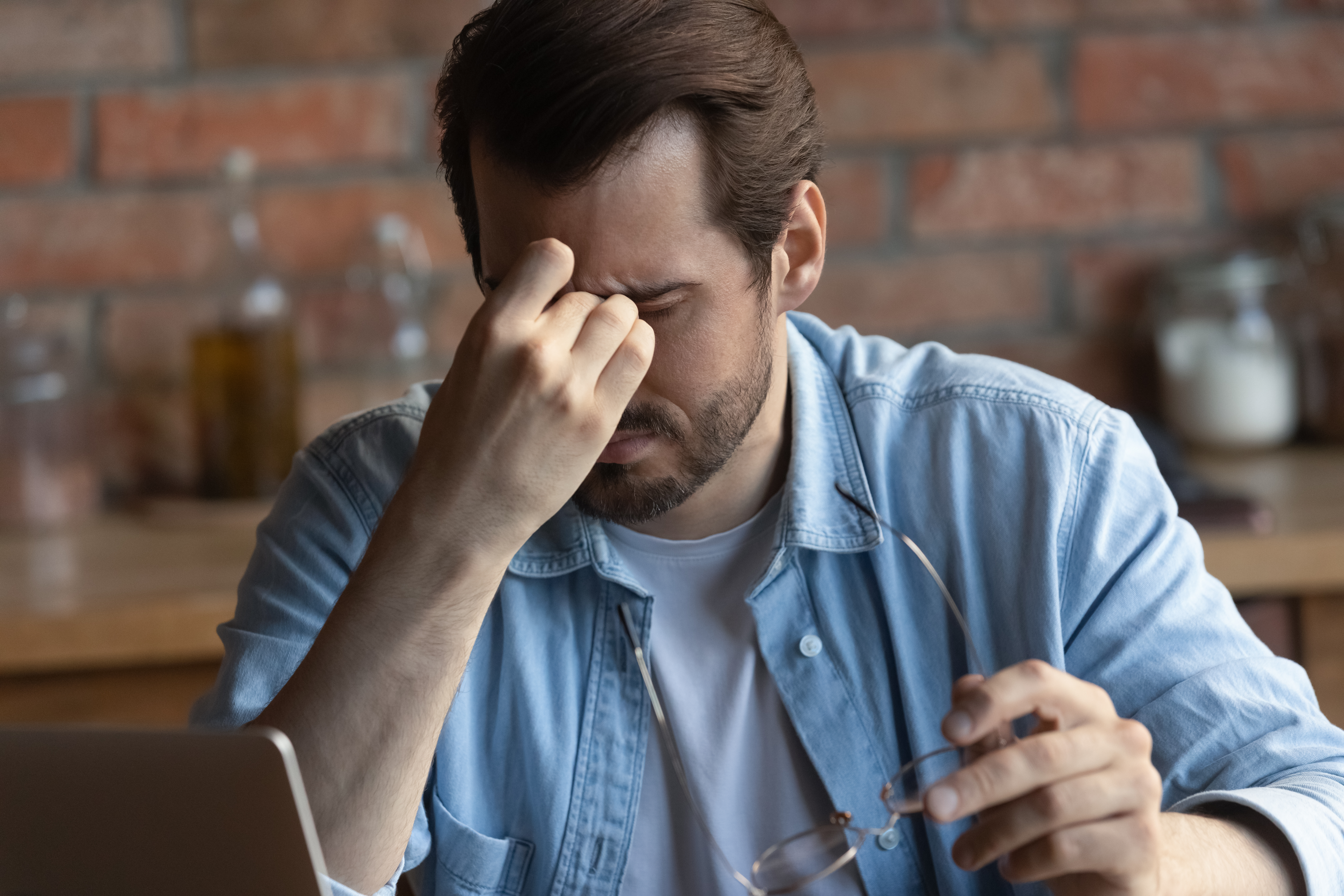 Man with glasses rubes his eyes | Source: Shutterstock.com