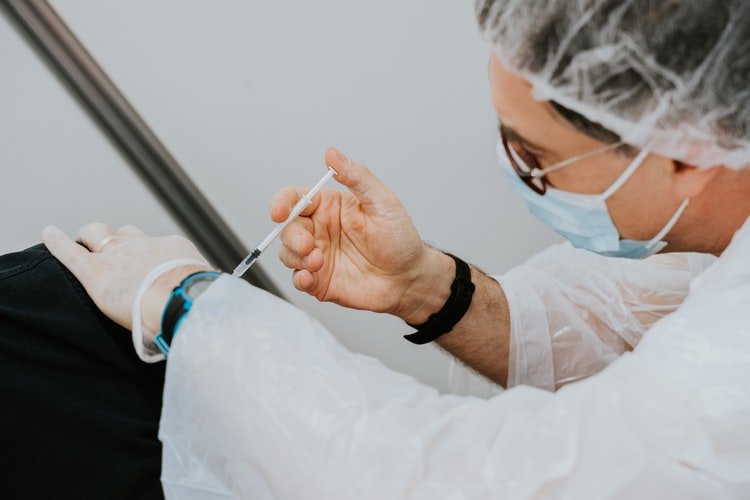 Un homme qui se fait vacciner. | Photo : Unsplash