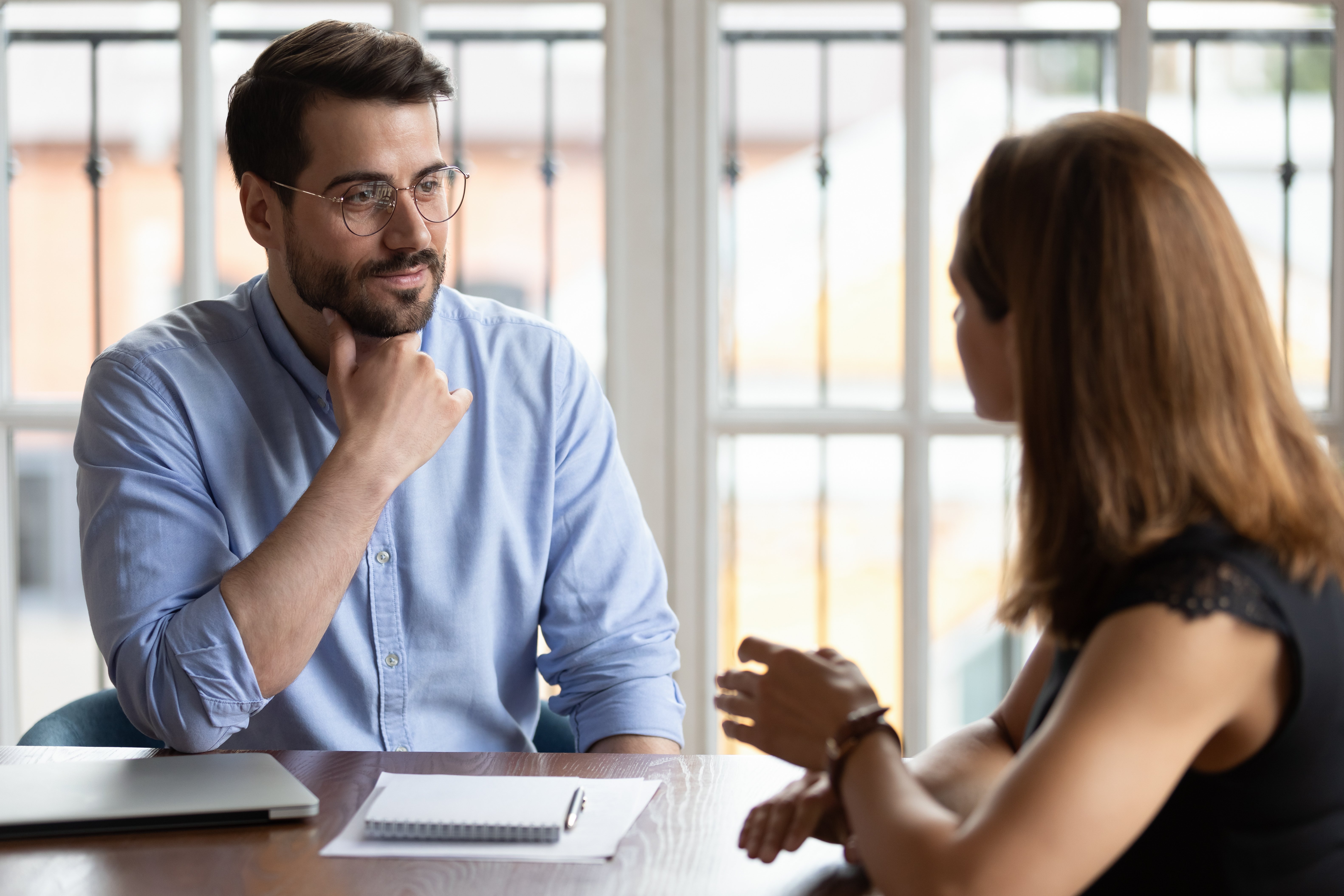 Hombre hablando con mujer en oficina. | Foto: Shutterstock