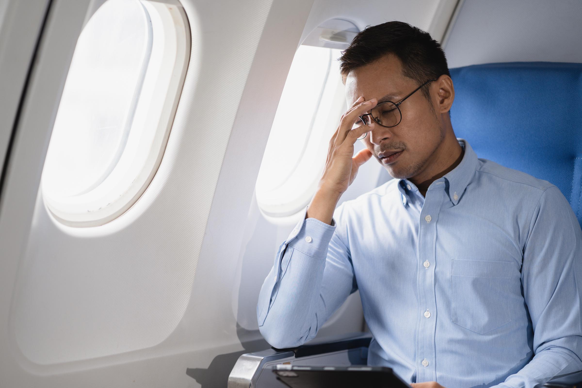 Embarrassed man inside a plane | Source: Shutterstock
