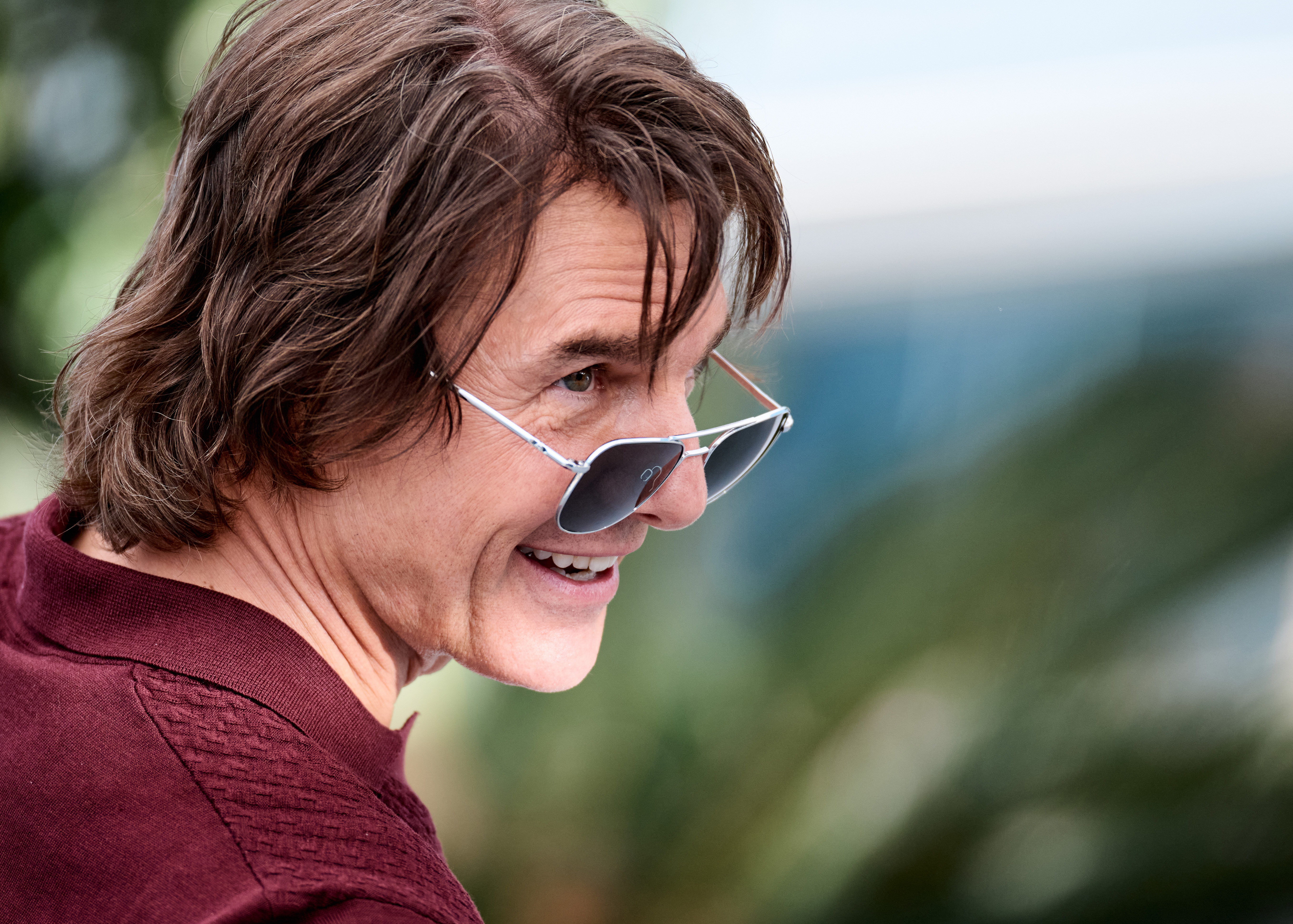 Tom Cruise appears relaxed and upbeat as he greets photographers in Cannes. Sporting tinted aviator sunglasses and a burgundy polo shirt, the actor attends the “Mission: Impossible – The Final Reckoning” photocall at the 78th Cannes Film Festival.