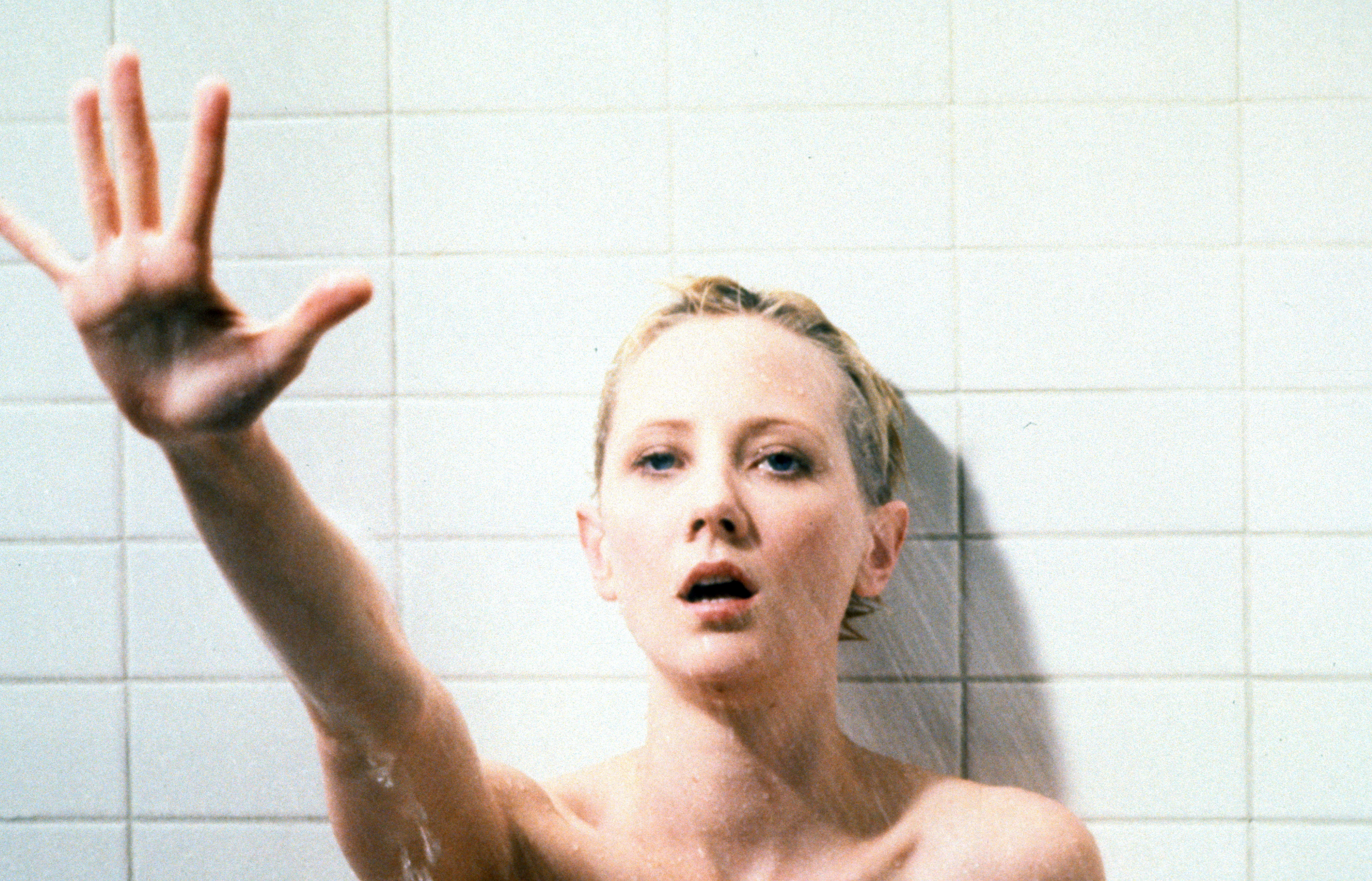 A distressed woman sticking her hand out while in the shower | Source: Getty Images