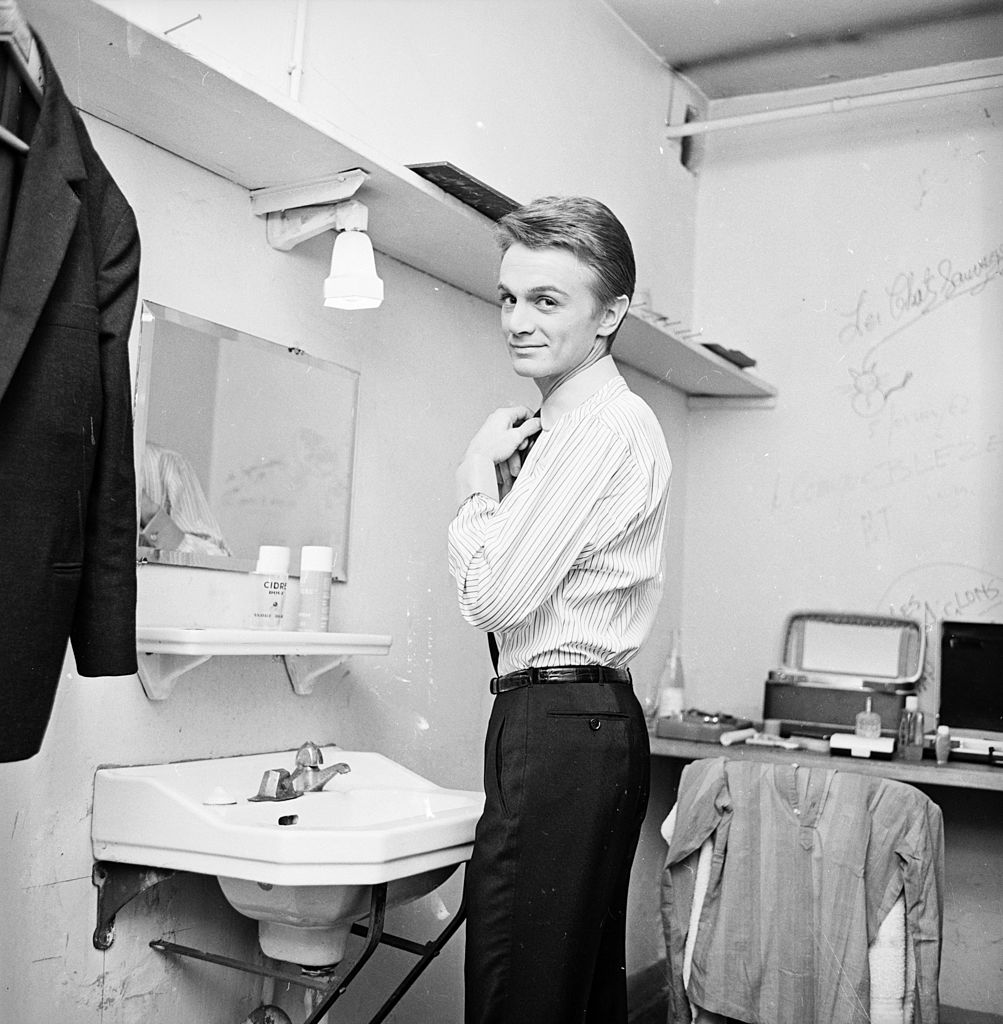 Claude François mettant une cravate. l Sources : Getty Images