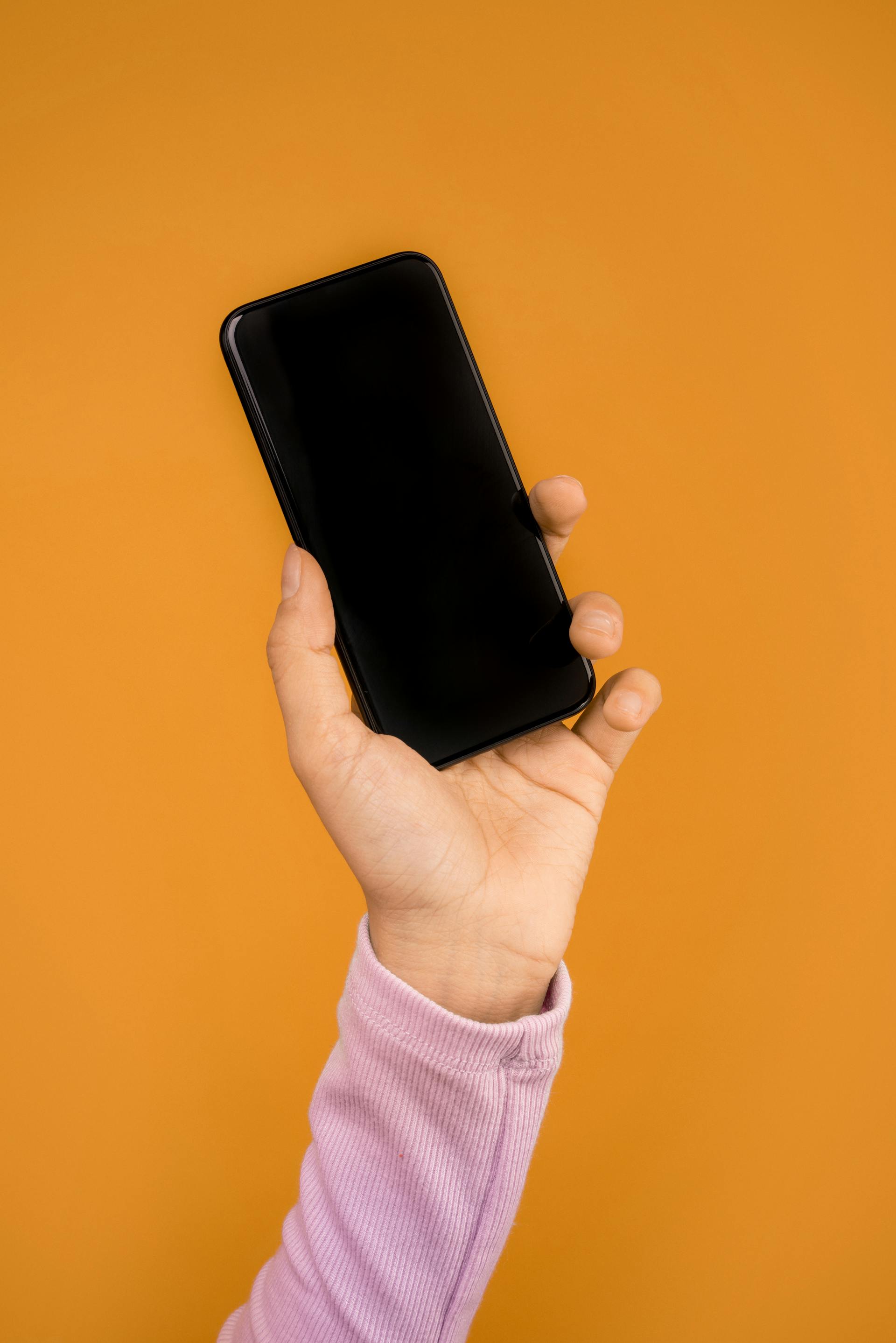 A woman holding up her phone | Source: Pexels