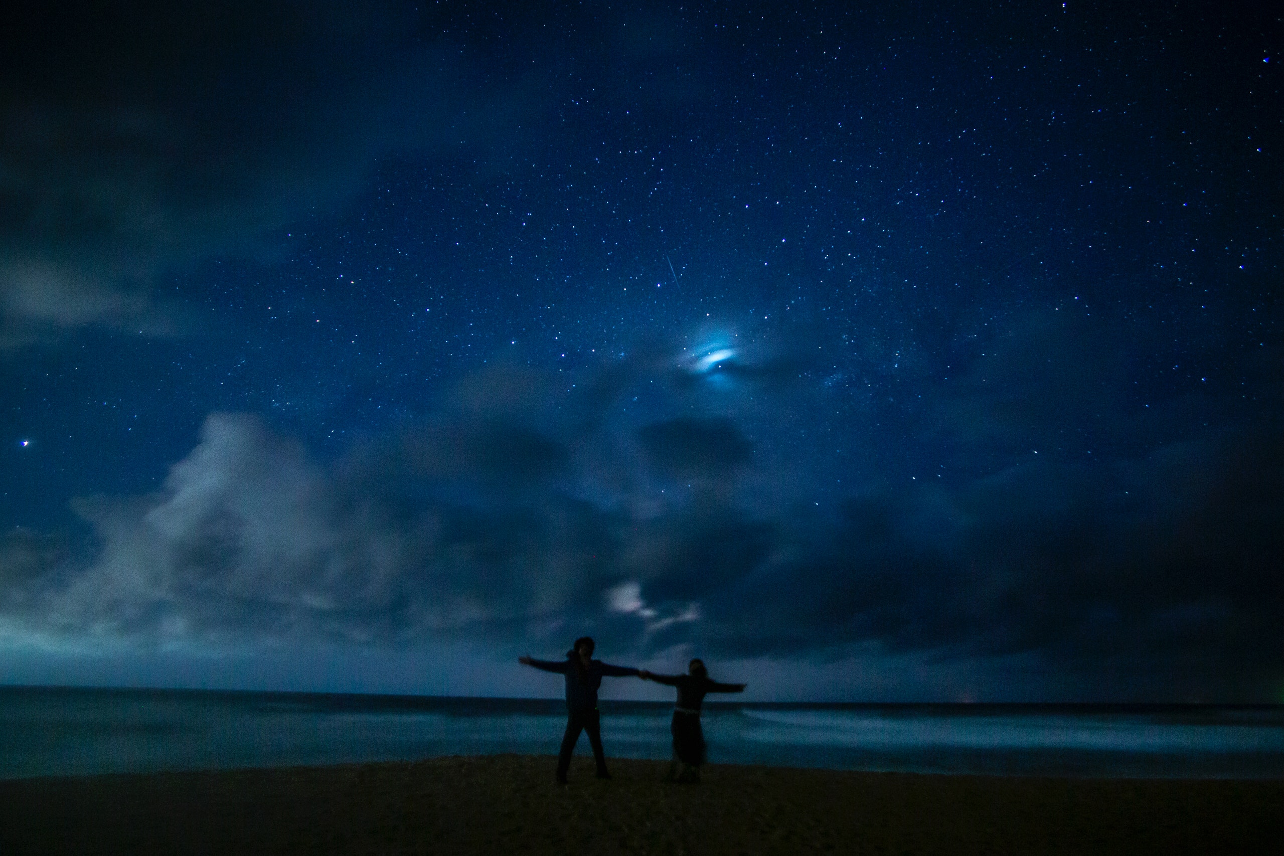 A couple on the beach under a starry sky. | Source: Pexels