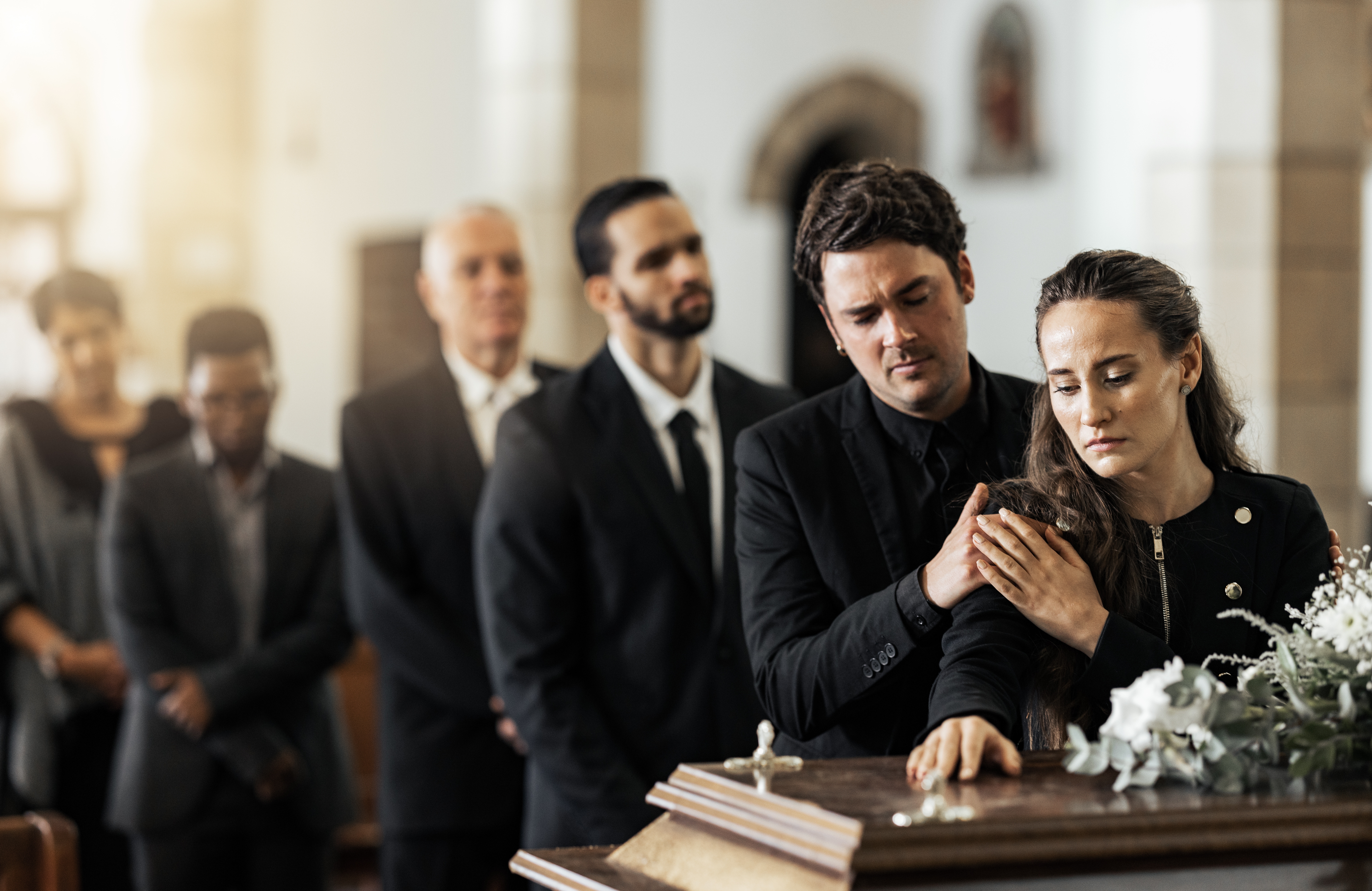 People standing near a coffin | Source: Shutterstock