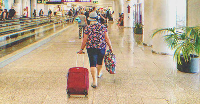 Una mujer camina por un pasillo con una maleta. | Foto: Shutterstock