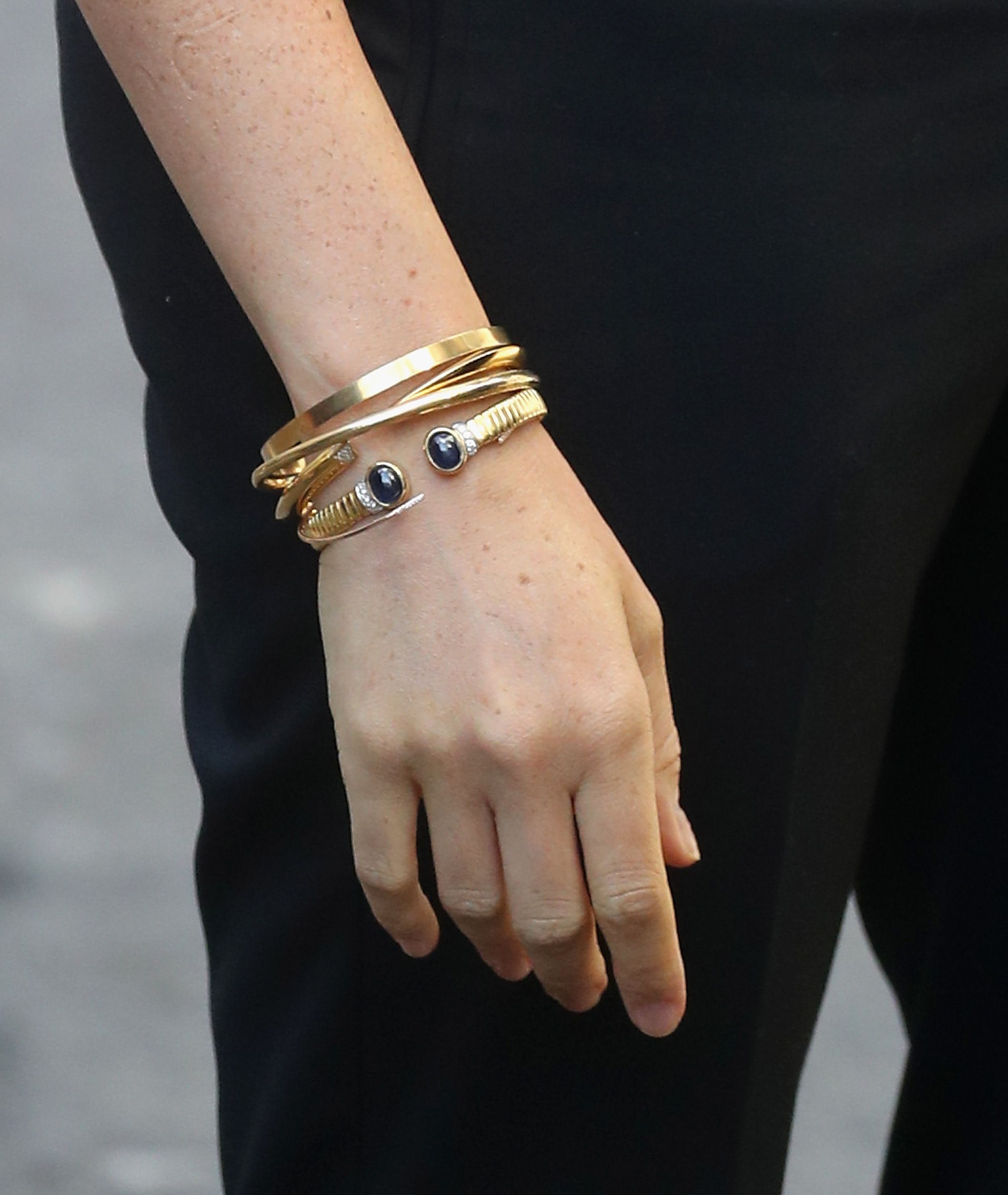 Stacked gold jewelry on a hand. | Source: Getty Images