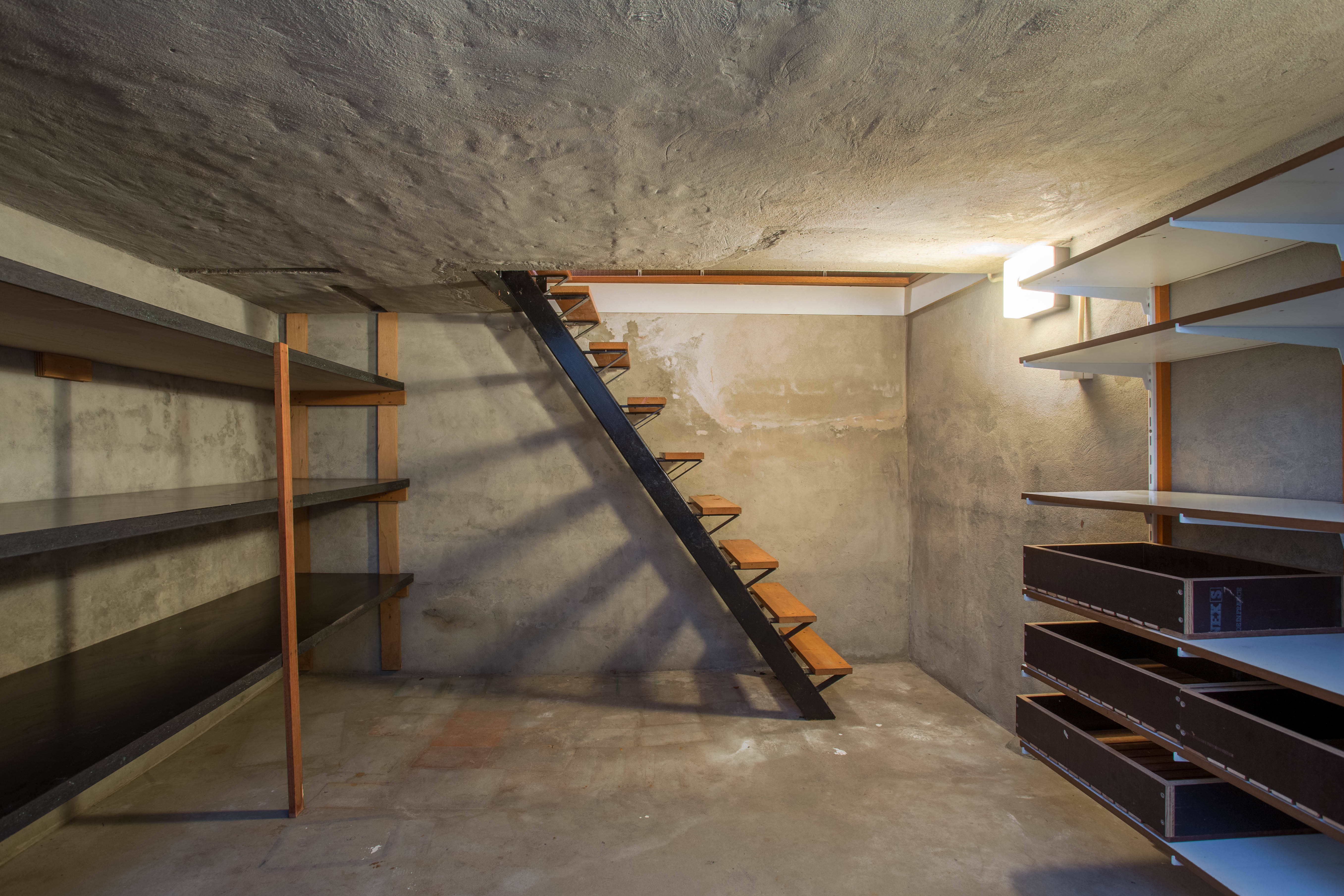 Basement in a building with little light and a wooden stairs. | Source: Shutterstock