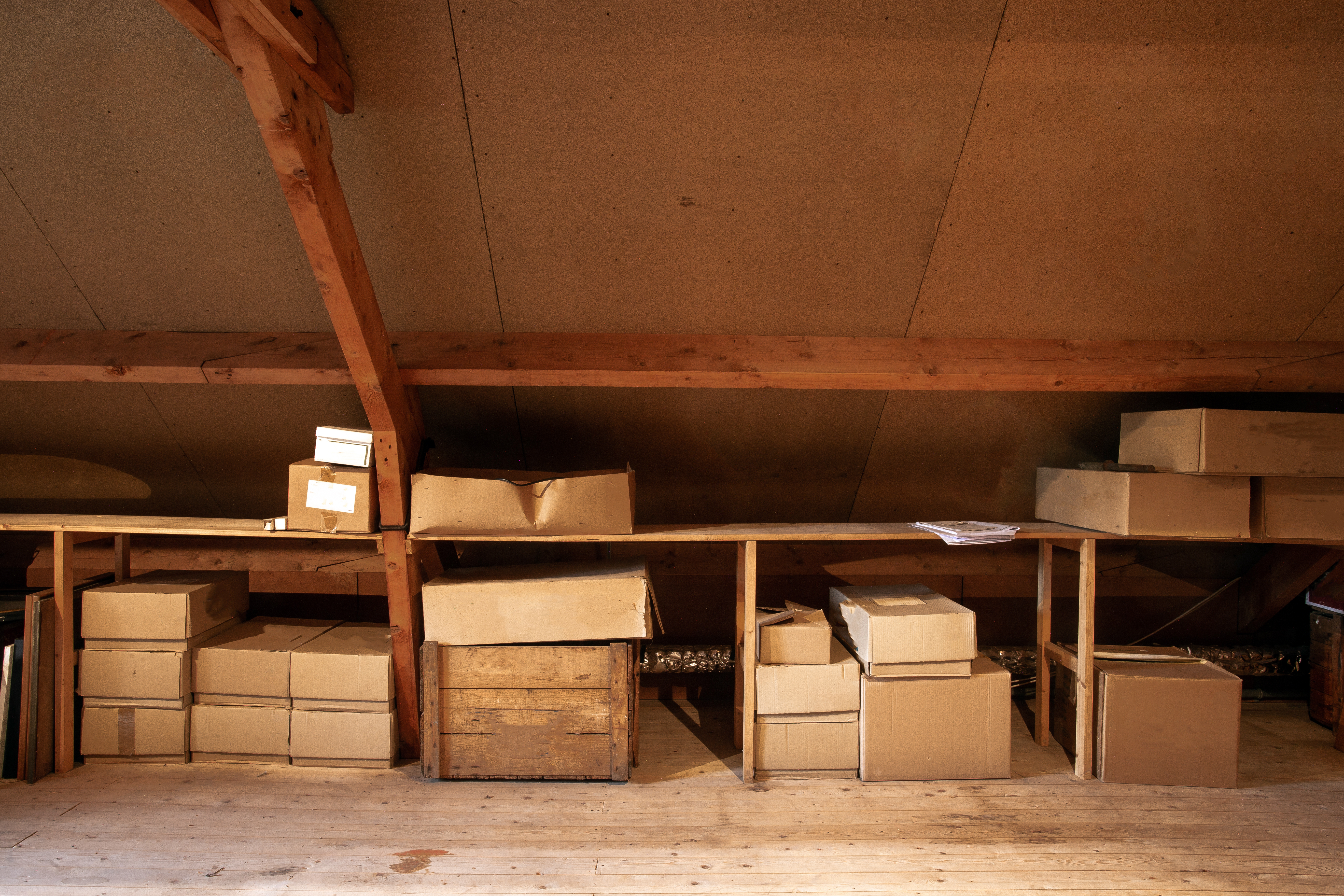 An old wooden attic interior with old cardboard boxes for storage | Source: Shutterstock