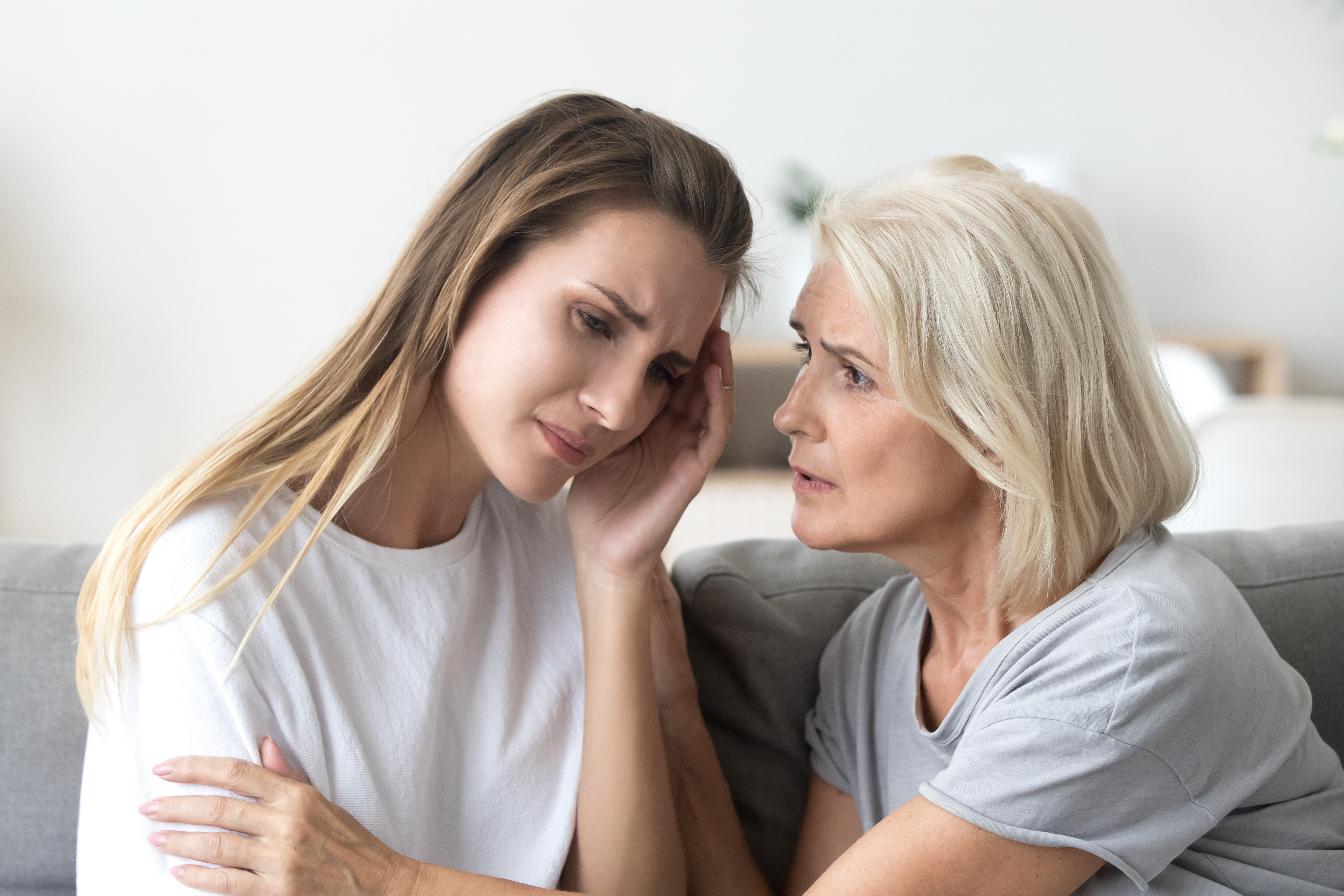 An older woman consoling a worried younger woman | Source: Shutterstock