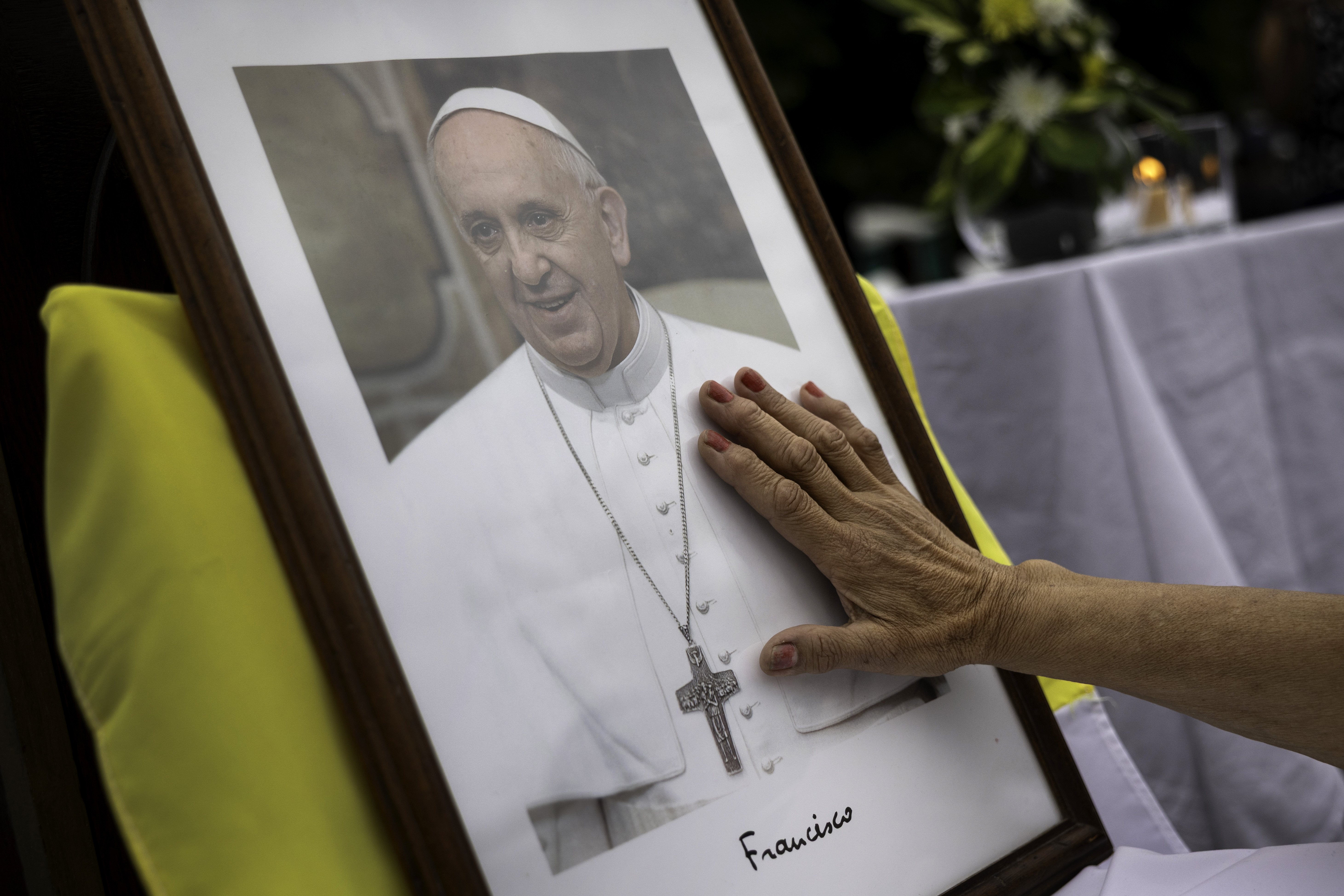 A woman touches a portrait of Pope Francis following a Catholic Mass held to pray for the ailing Pontiff in Buenos Aires, Argentina on February 24, 2025. | Source: Getty Images