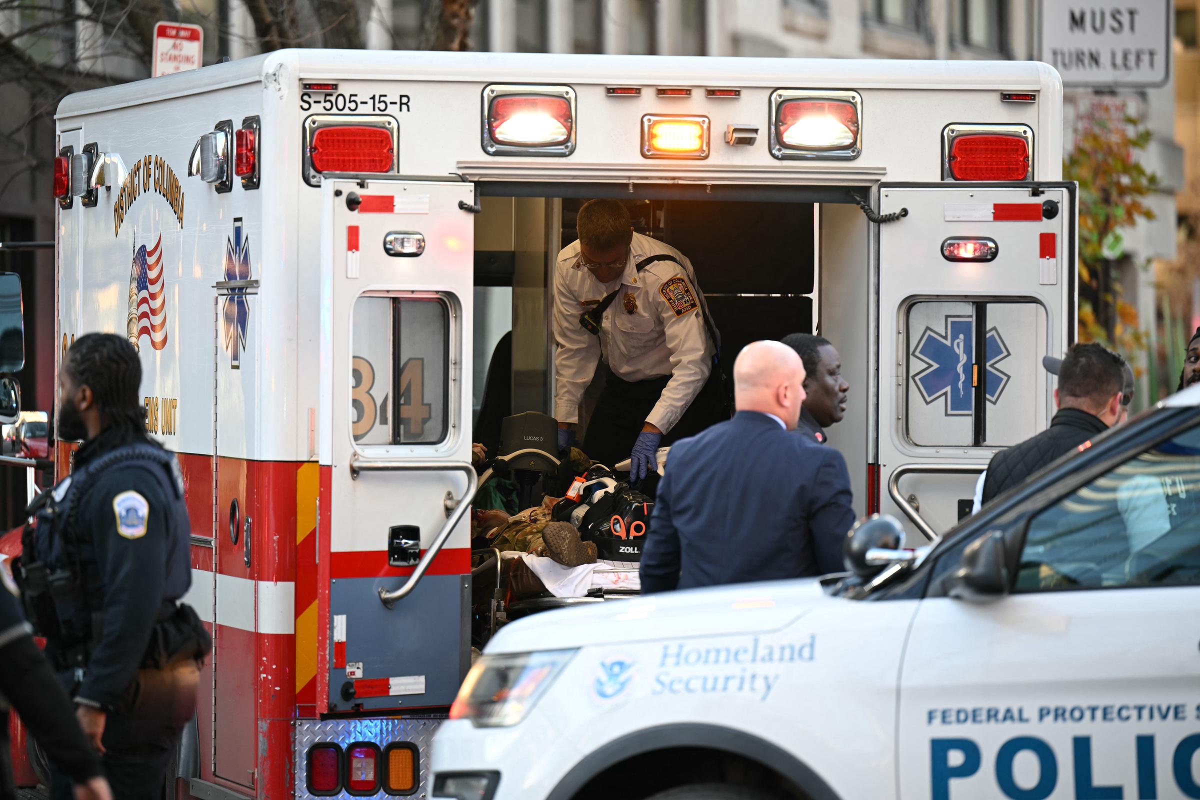 An unidentified man in military uniform lies on a stretcher inside an ambulance on November 26, 2025 in downtown Washington, DC | Source: Getty Images
