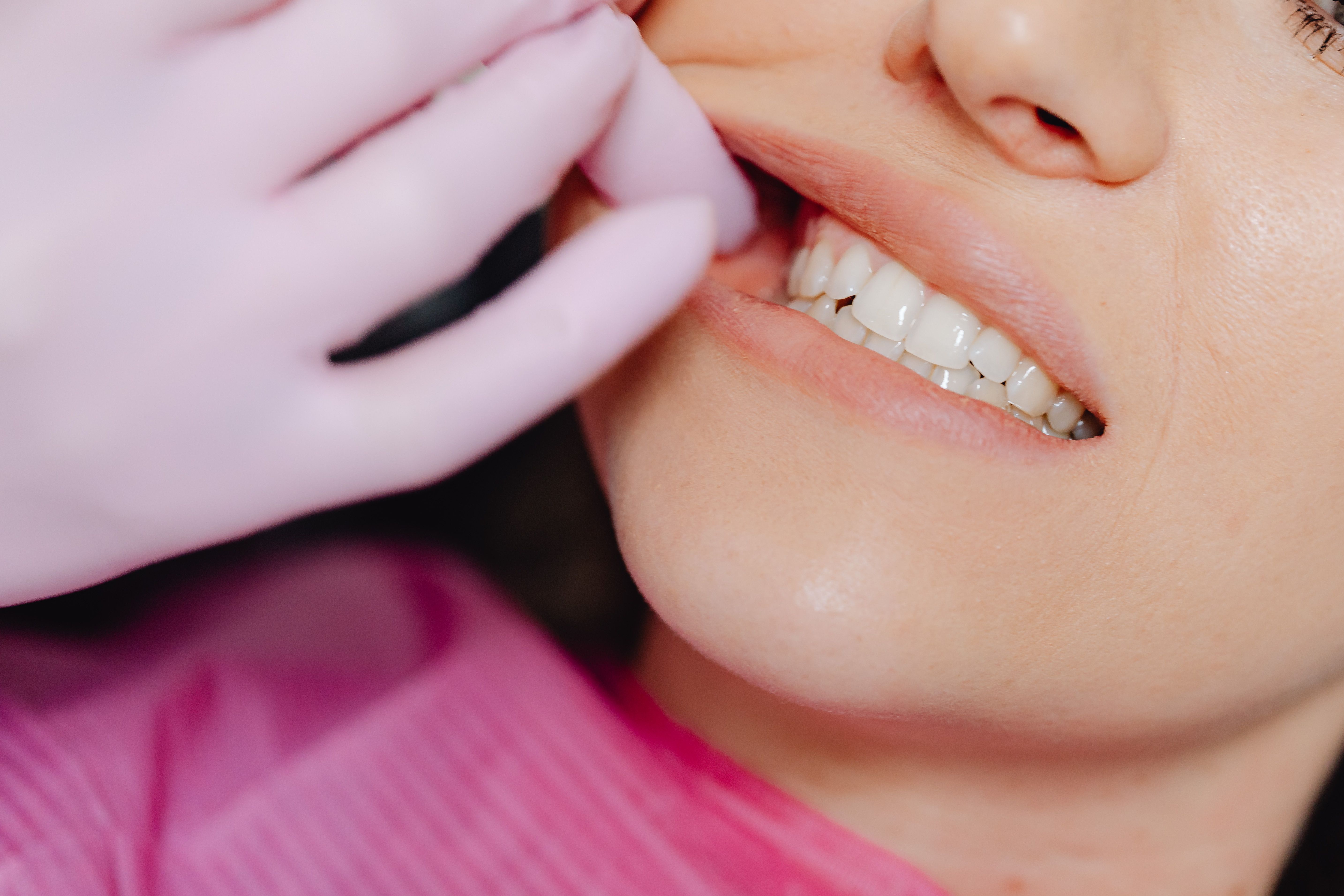 Person dissecting the gum portion of a woman's mouth | Source: Pexels