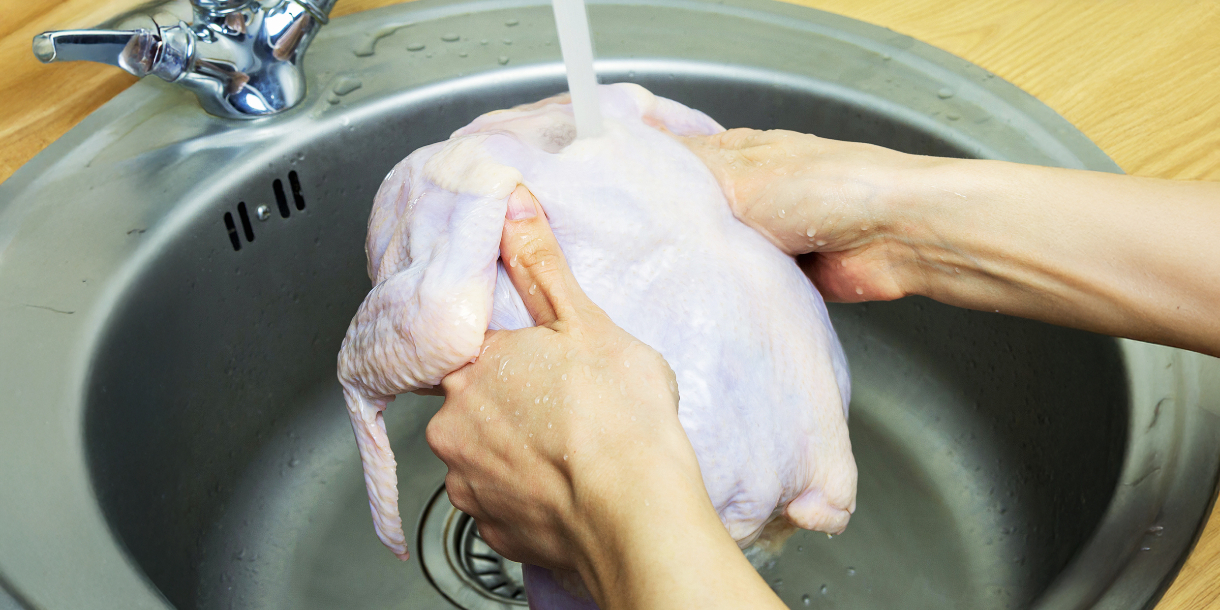 A person washing an uncooked chicken | Source: Getty Images