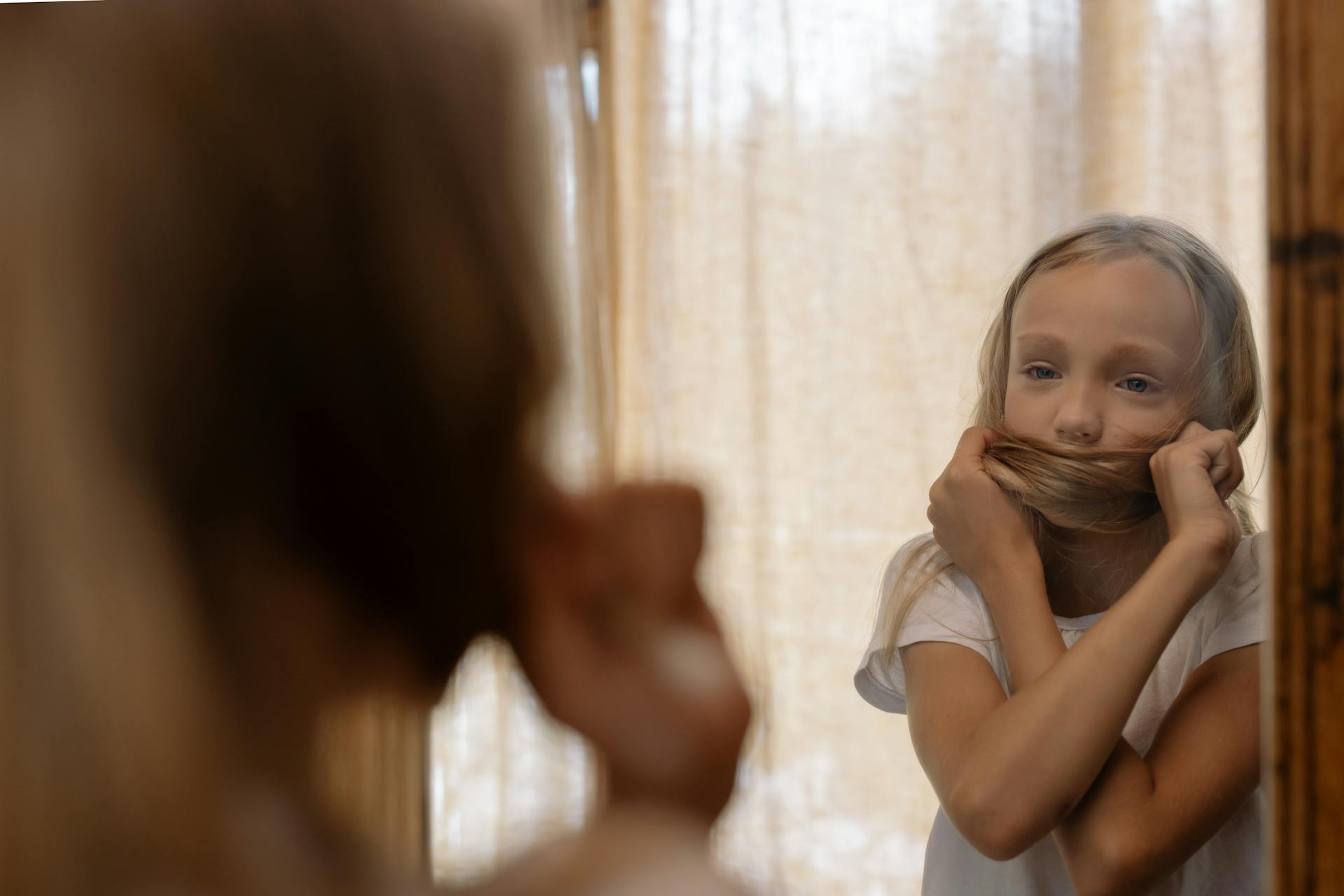 A girl looking at herself in the mirror | Source: Pexels