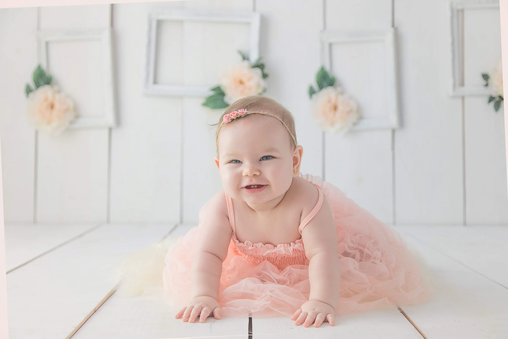A smiling baby girls crawls on the floor. | Source: Unsplash