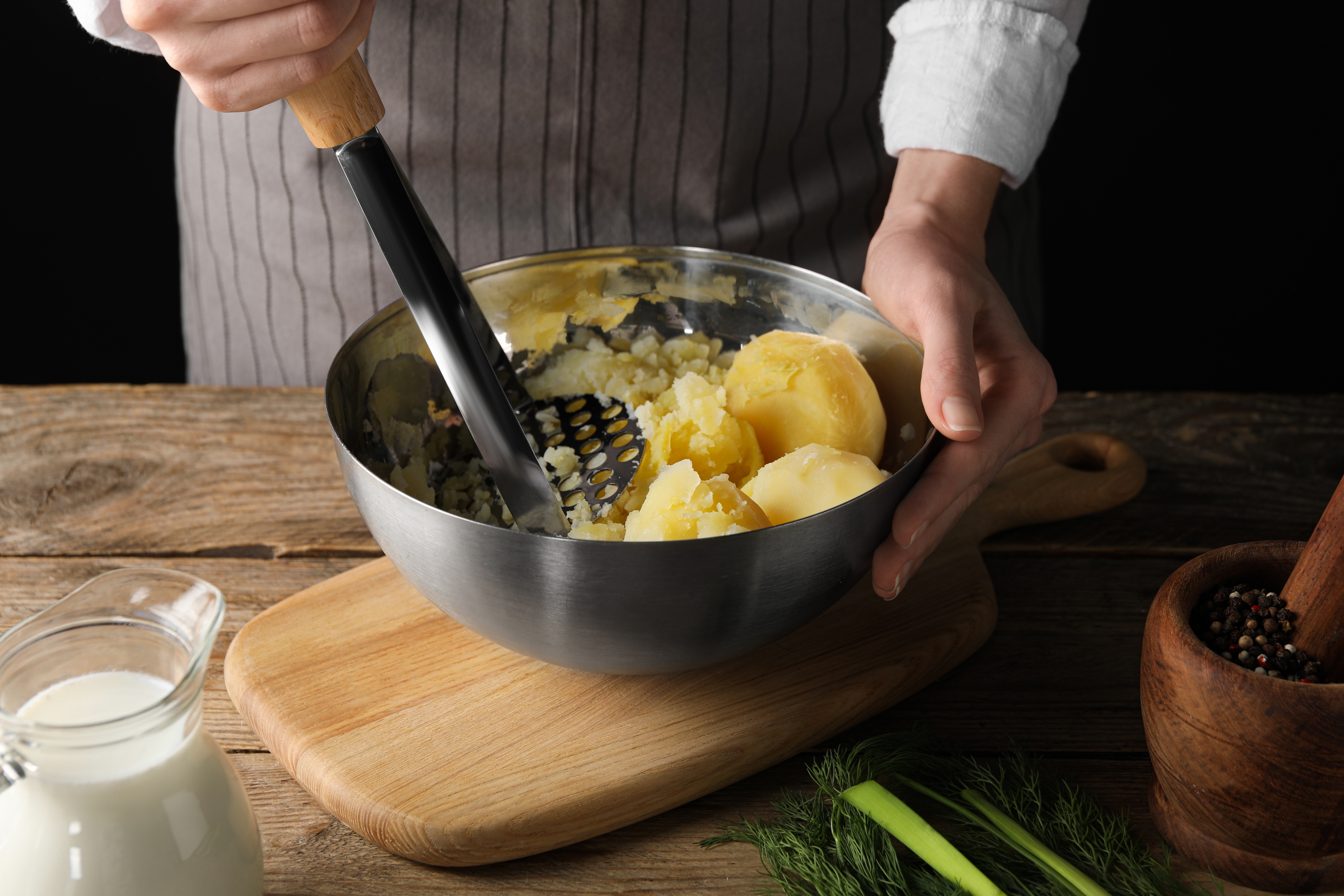 A person using a potato masher | Source: Shutterstock