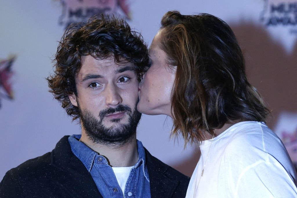 Laure Manaudou embrasse son partenaire Jeremy Frerot du duo musical français Frero Delavega à leur arrivée au Palais des Festivals pour assister aux 17e NRJ Music Awards à Cannes, dans le sud-est de la France, le 7 novembre 2015. | Photo : Getty Images