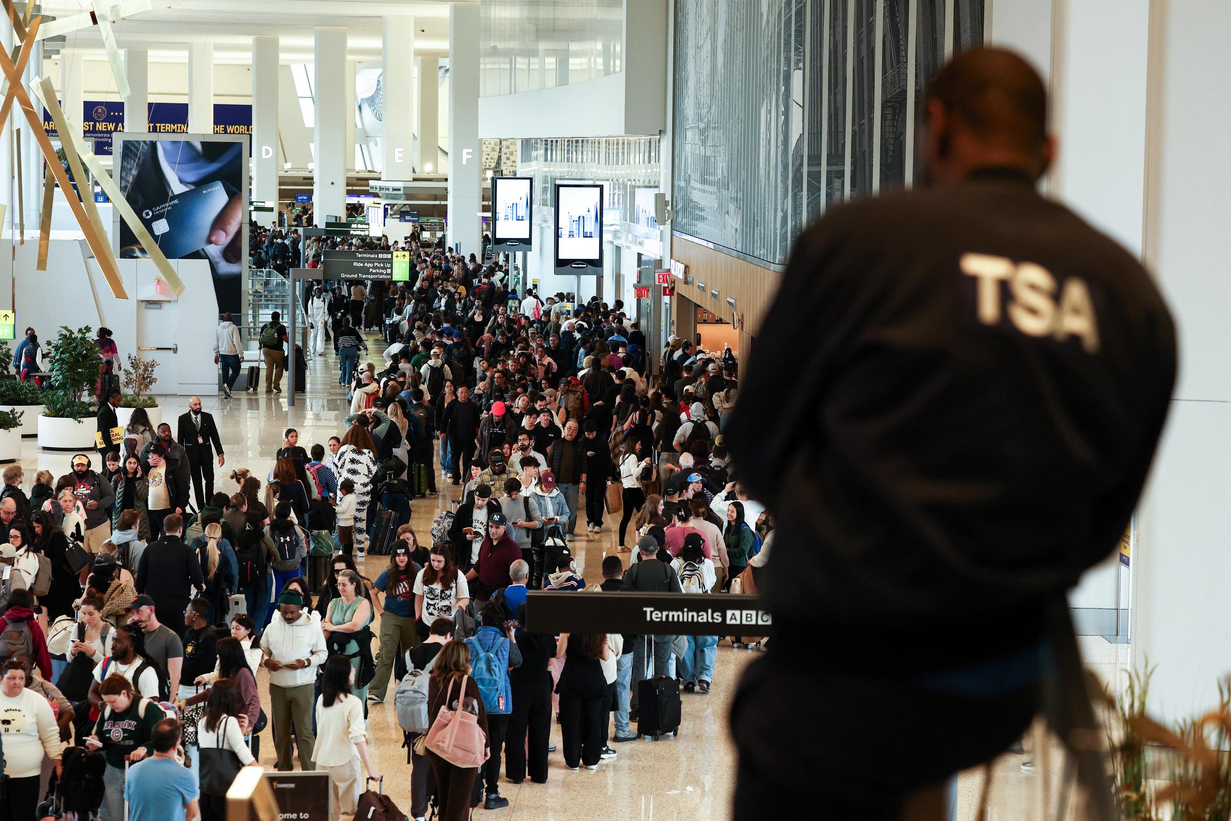 A TSA agent looks over crowded security lines at LaGuardia Airport as passengers queue for screening, on March 22, 2026 | Source: Getty Images