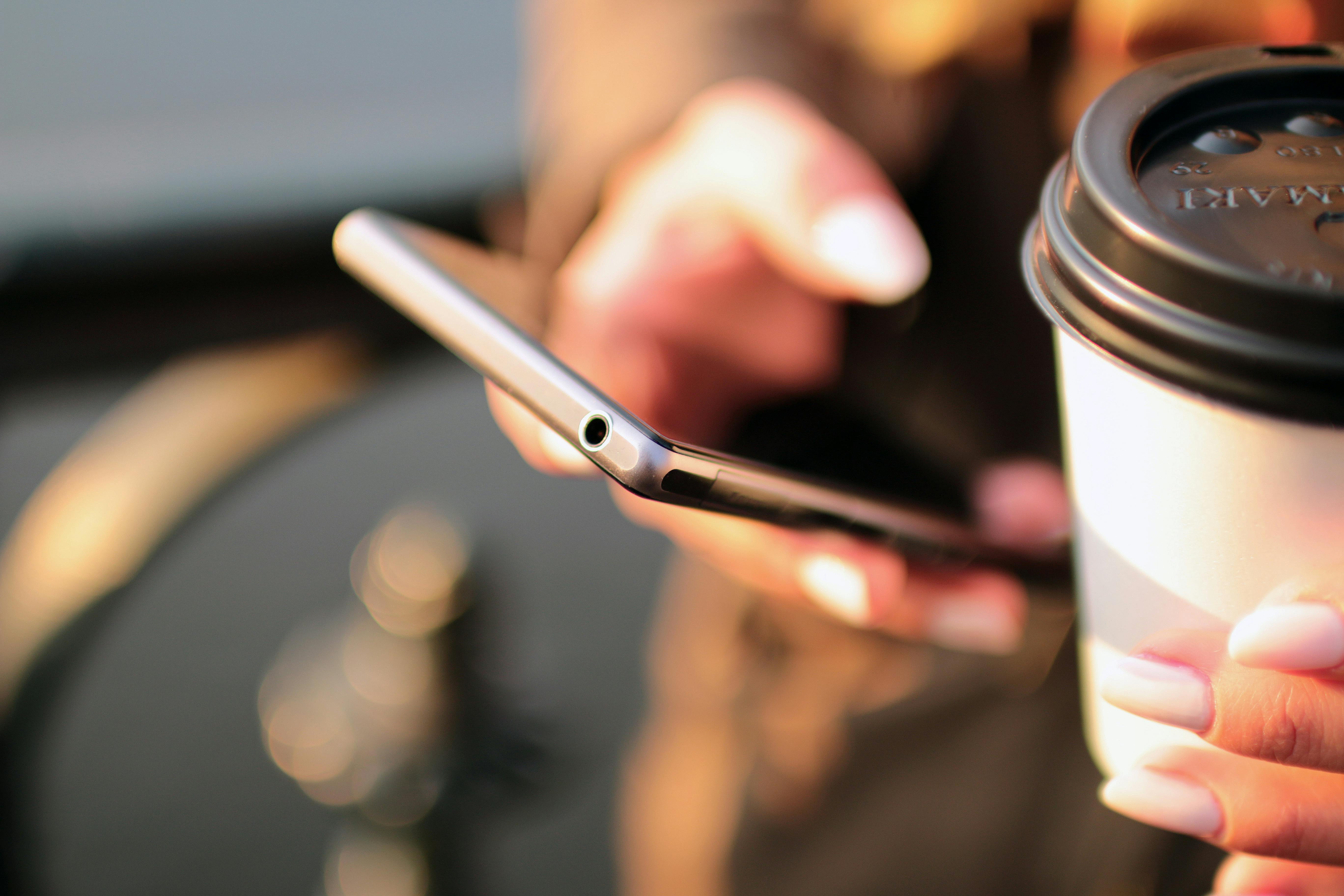 For illustration purposes only. Woman reads text on her phone while drinking coffee | Source: Pexels