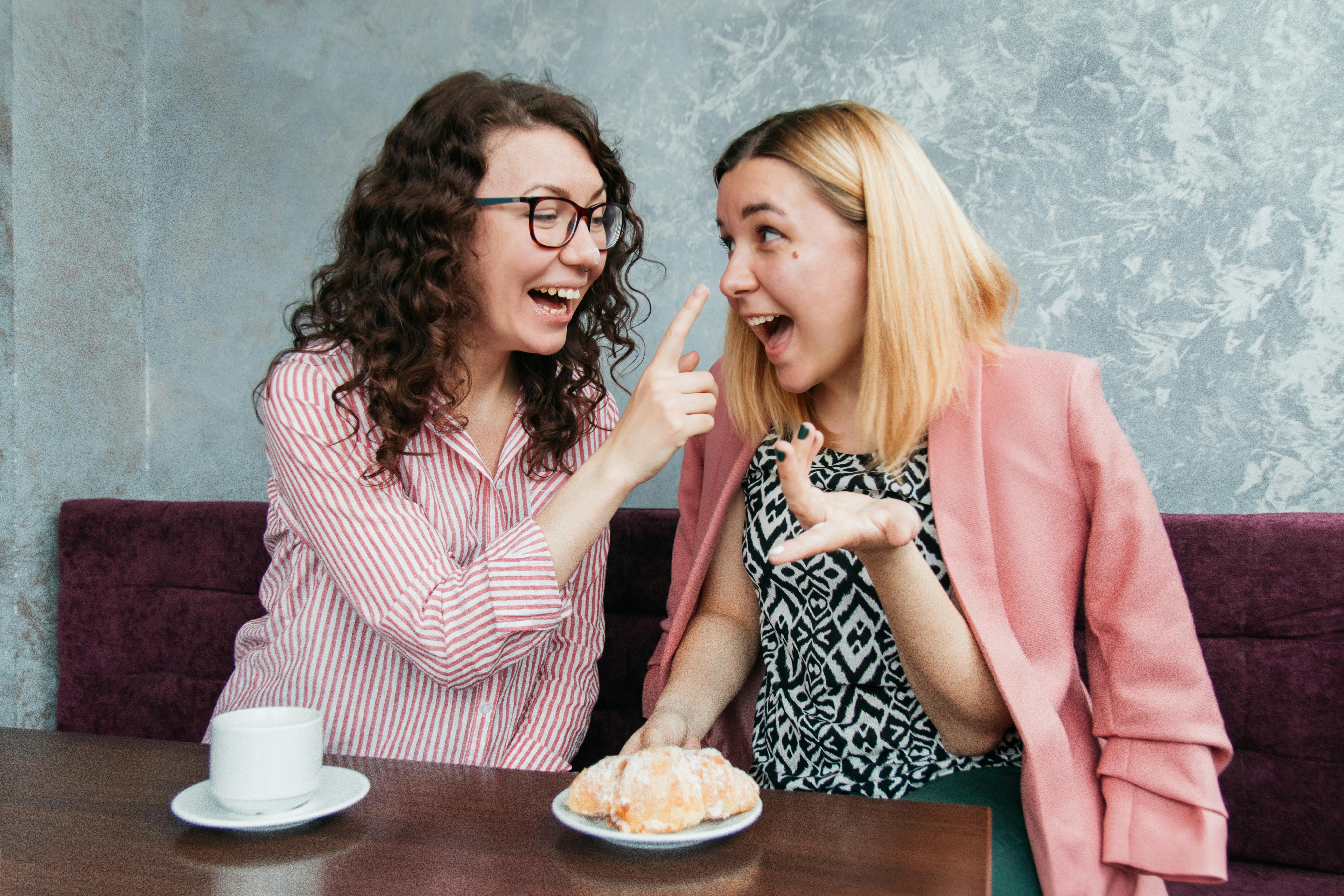 Two friends laughing at a café | Source: Pexels