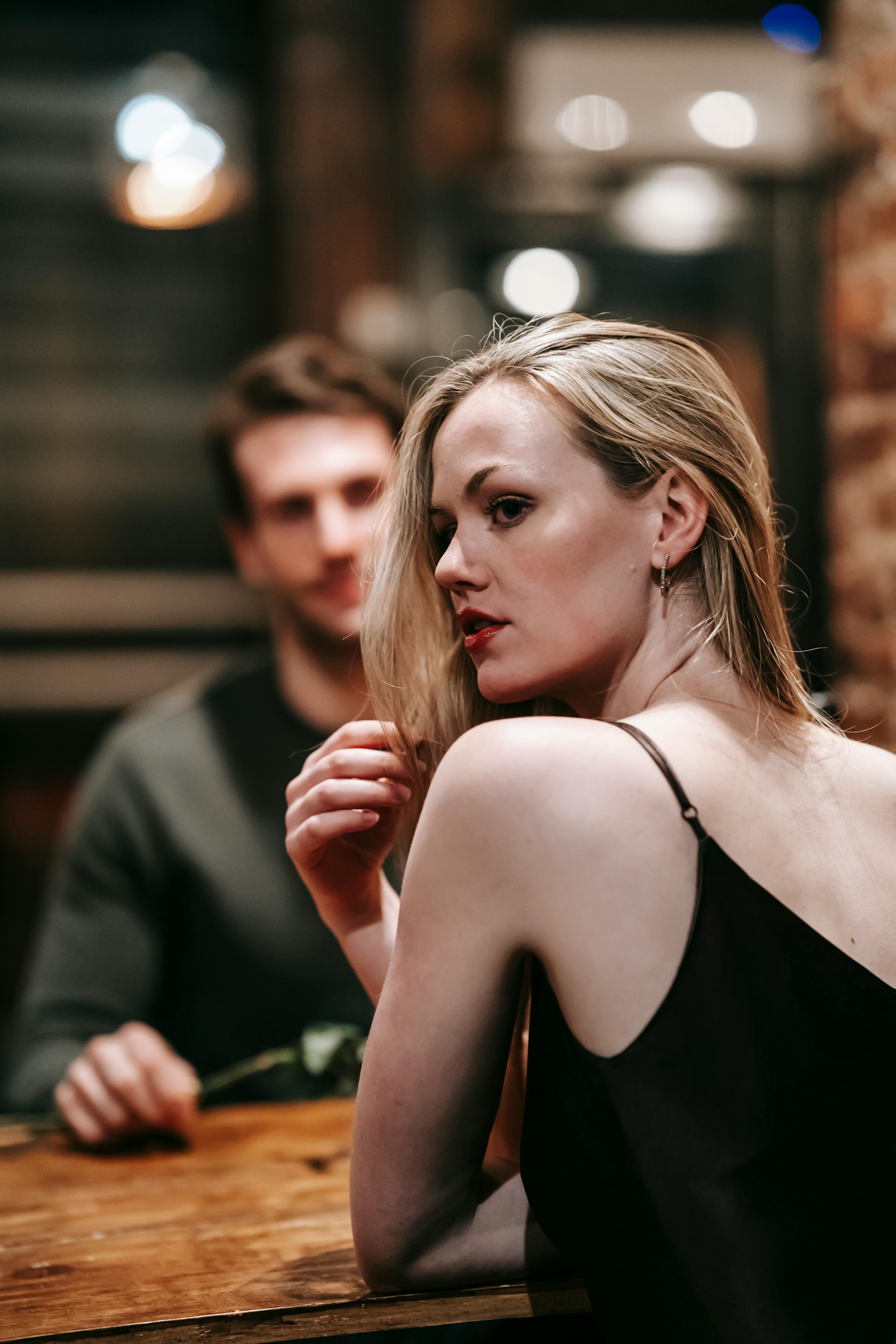 A woman looking over her shoulder while having dinner with a man | Source: Pexels