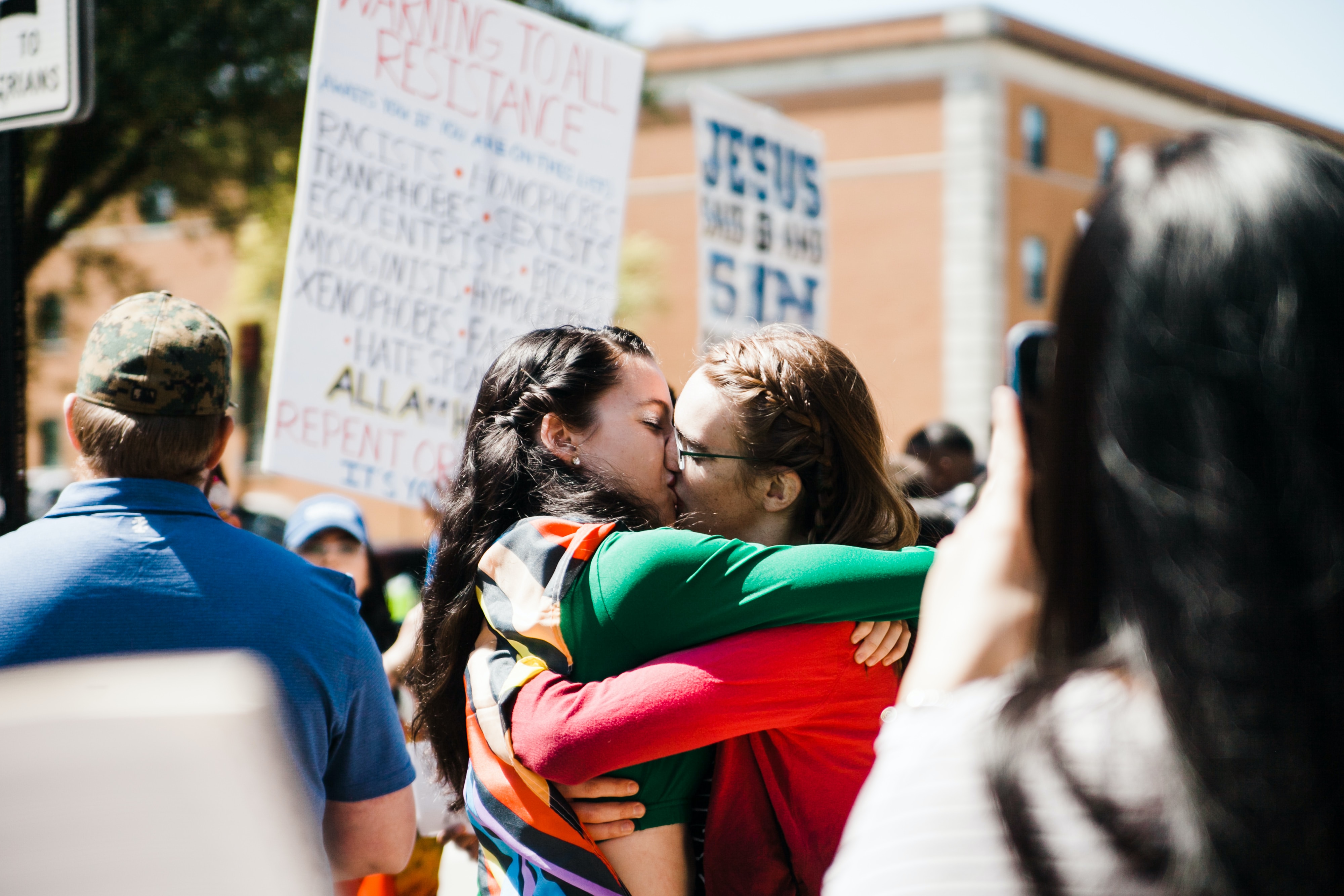 Two couples kissing in the middle of a protest. | Source: Unsplash