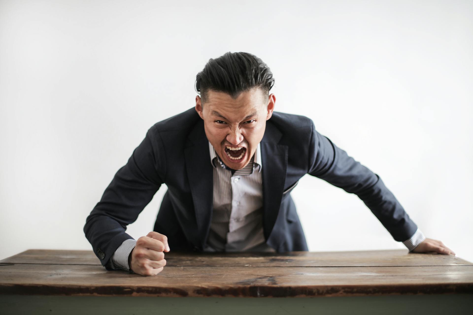 A furious man hits a desk | Source: Pexels