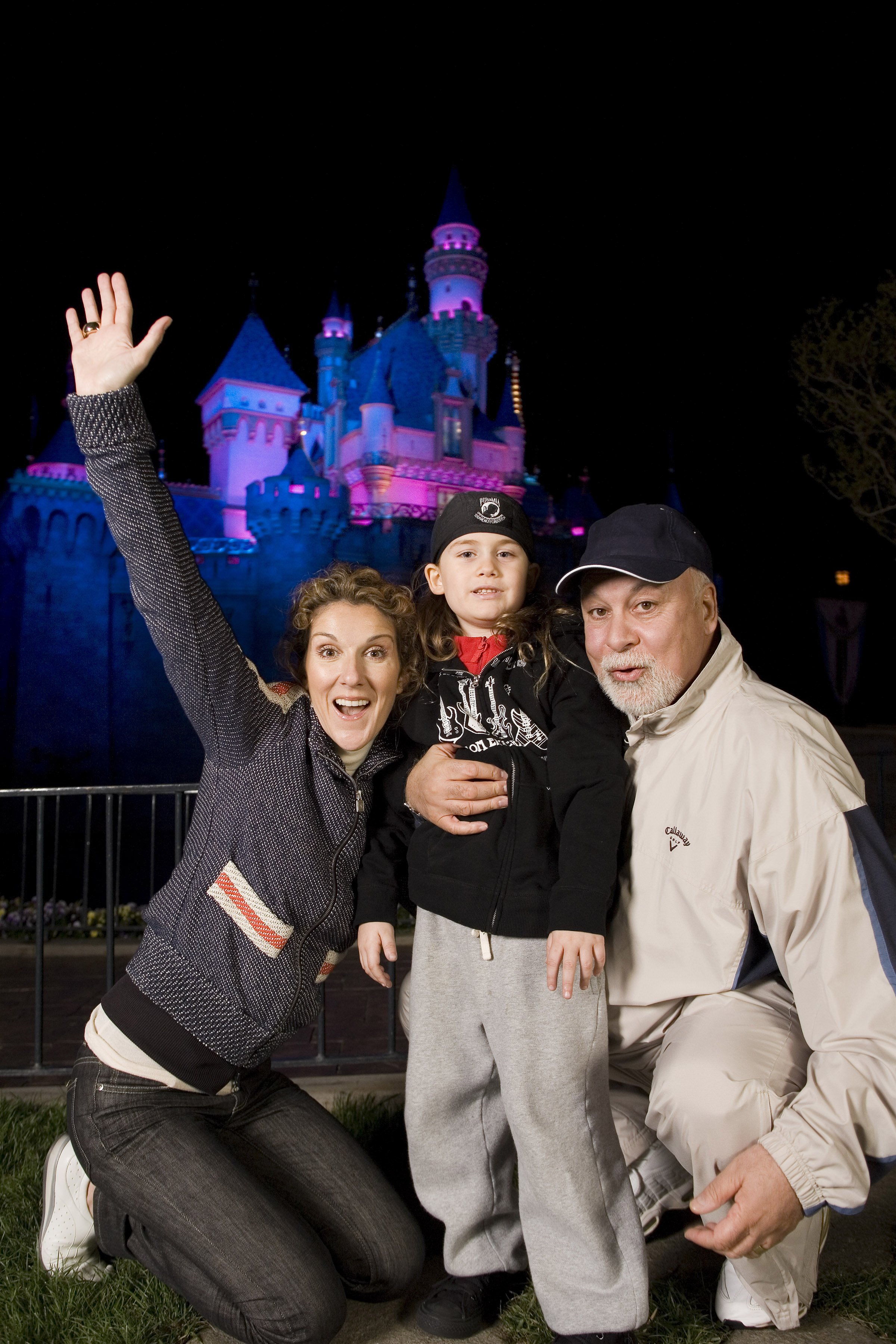 Celine Dion, su hijo René-Charles, de 6 años, y su esposo René Angélil afuera del Castillo de la Bella Durmiente en Disneyland en Anaheim, California | Foto: Getty Images
