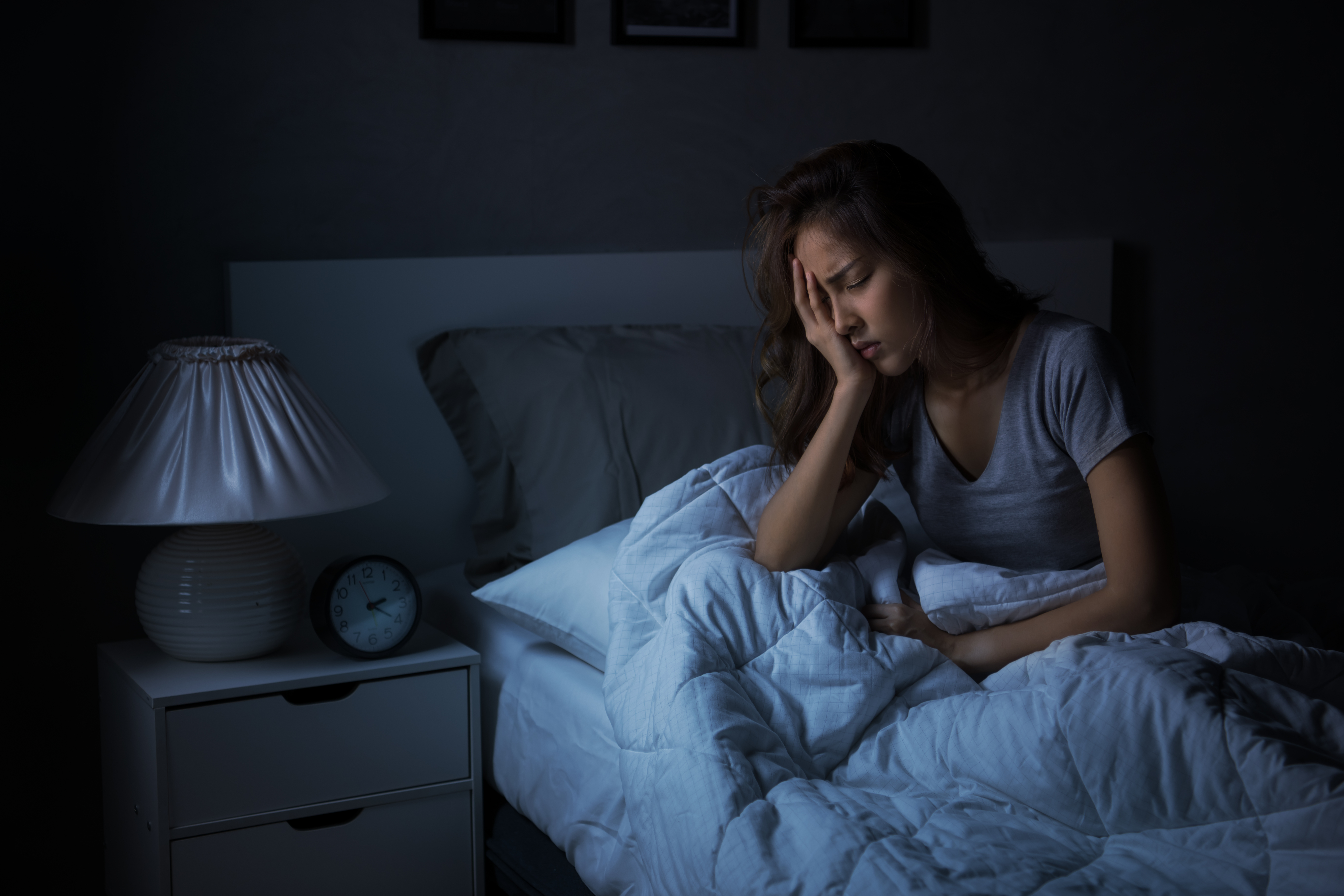 Depressed young woman sitting in bed cannot sleep from insomnia. | Source: Shutterstock