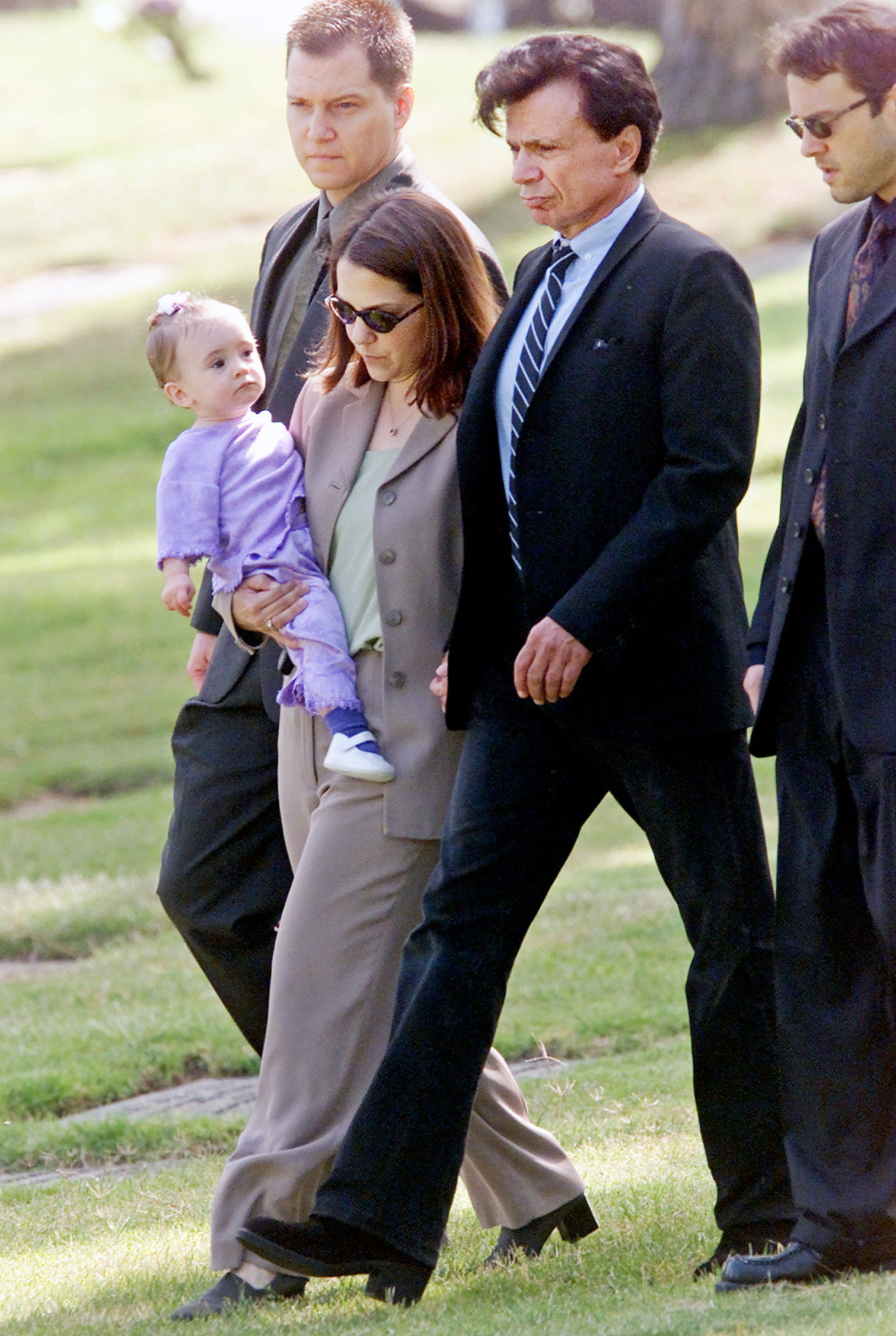 (L-R) Unidentified man, Delinah Blake holding Rose Lenore Blake, Robert Blake, and Noah Blake walk to the gravesite of Bonny Lee Bakley during a brief funeral ceremony on May 25, 2001, in Los Angeles, California. | Source: Getty Images
