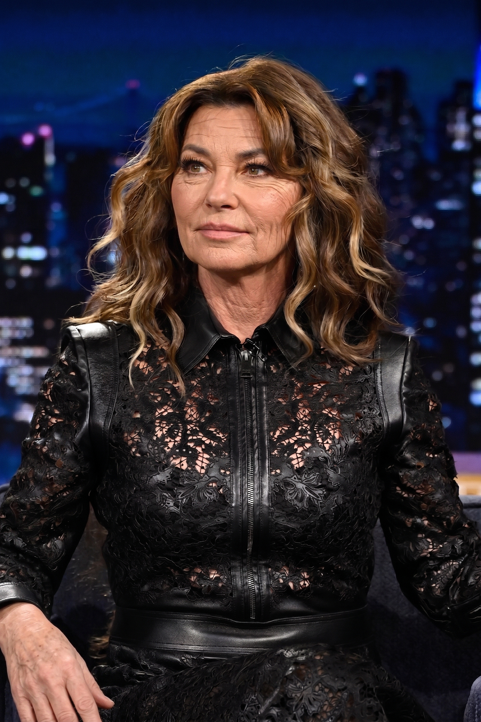 Reimagining Shania Twain's July 22, 2026 talk show appearance, this AI-edited portrait combines her chic lace-and-leather outfit with simulated natural cheek texture, delicate crow's feet, and subtle neck lines. | Source: Gemini