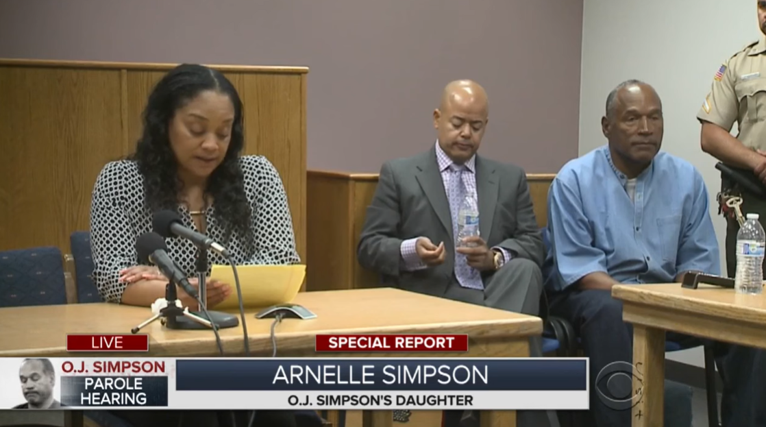 Arnelle Simpson speaks before a parole board as O.J. Simpson listens in the corner of the room during a parole board hearing in 2017 in Nevada. | Source: YouTube/CBSNewYork